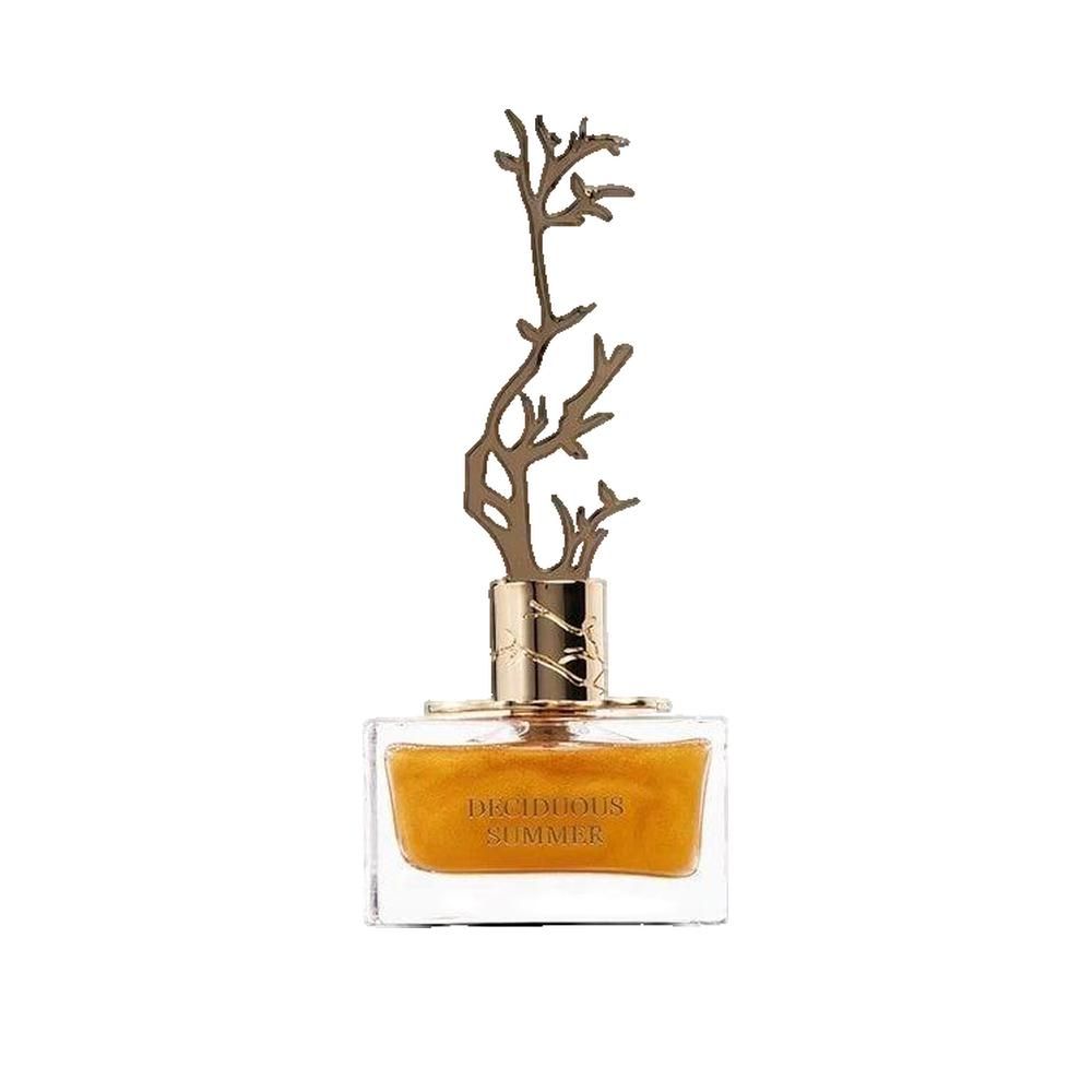 Rechteckiger Glasflakon mit goldfarbener Flüssigkeit. Goldfarbener, baumförmiger Verschluss. Aufschrift: DECIDUOUS SUMMER.