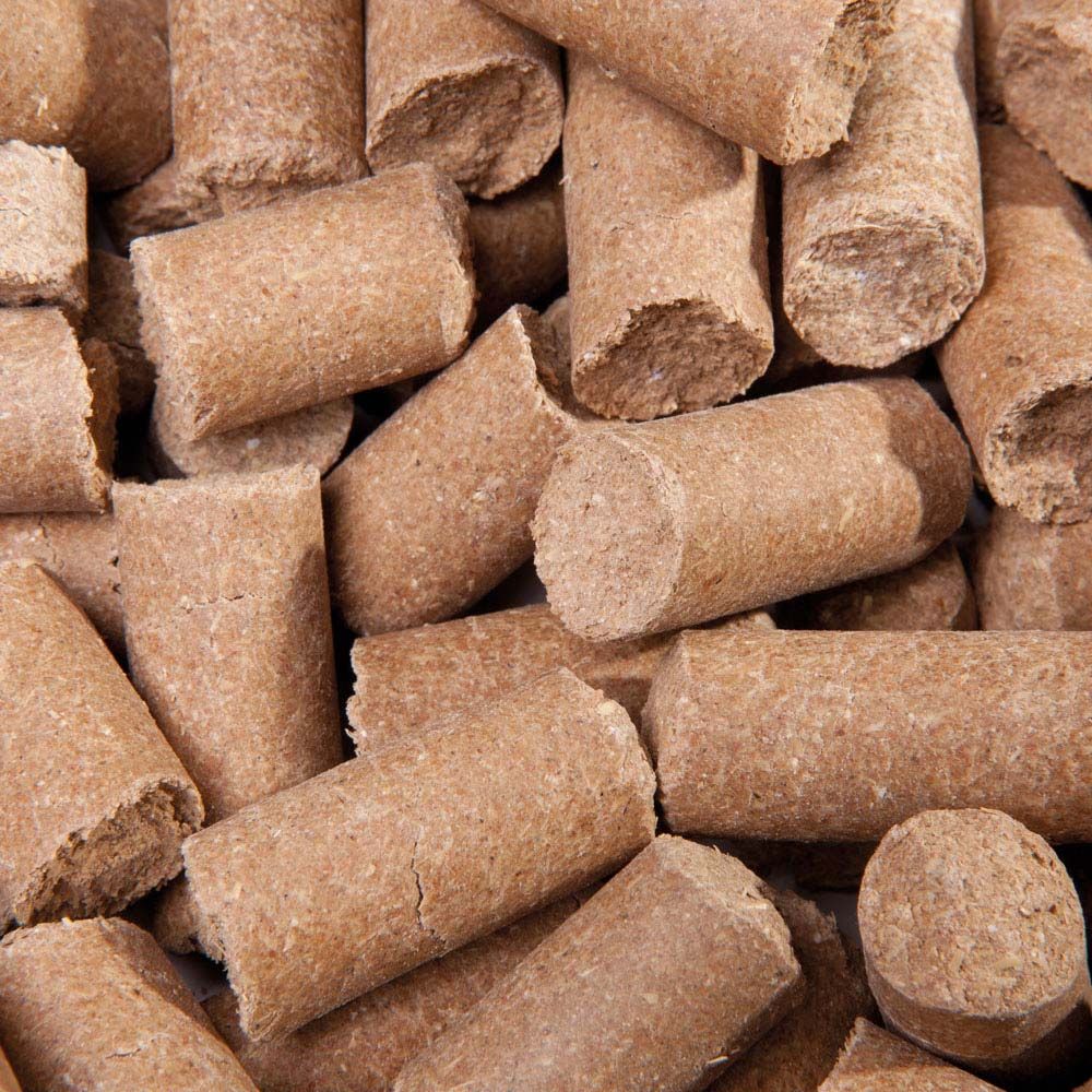 Nahaufnahme von zylindrischen, braunen Lecker Bricks. Die Bricks sind aus gepresstem Material und unregelmäßig geformt.
