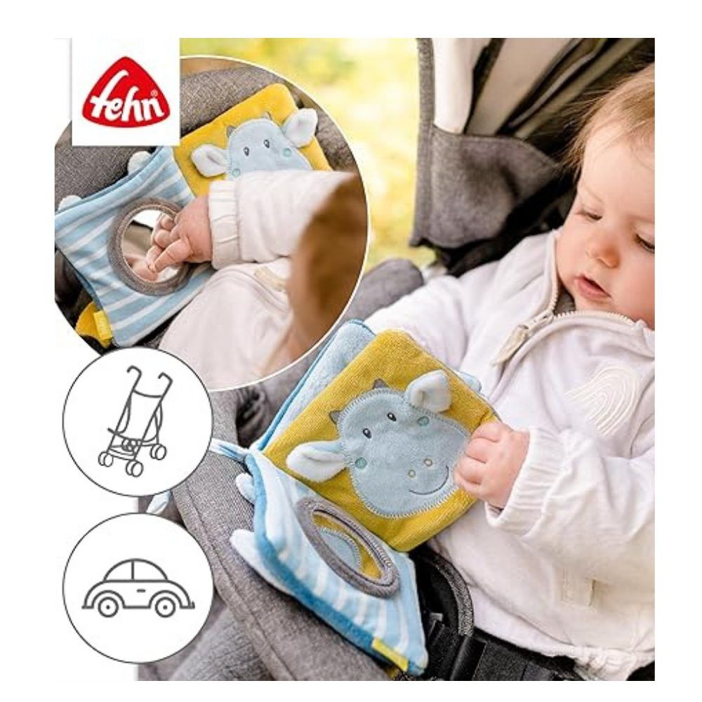 Baby sitzt im Kinderwagen und spielt mit Stoffbüchern. Marke: fehn. Mit Spiegel und Tier-Motiven. Im Hintergrund: Kinderwagen.