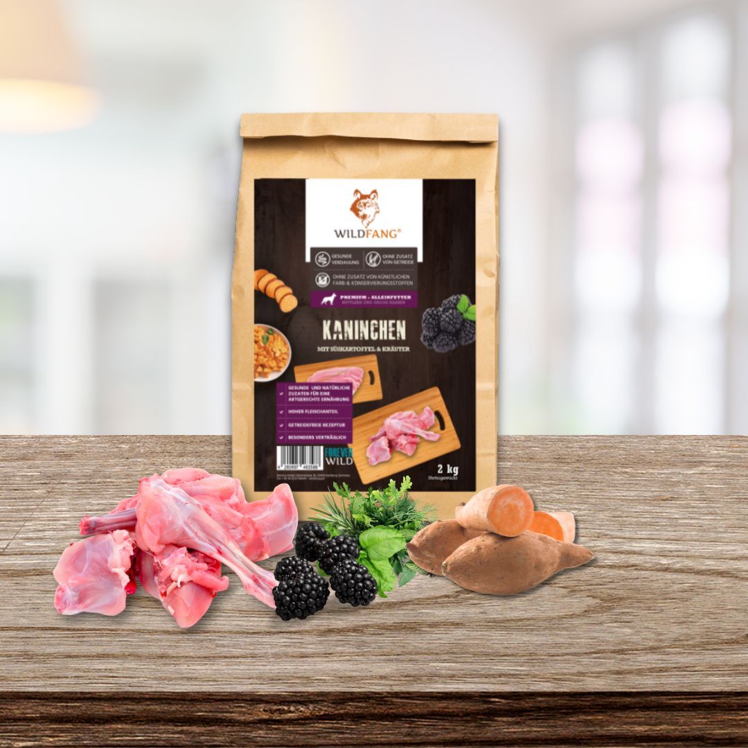 Hundefutter-Beutel und Zutaten: Kaninchen, Brombeeren, Süßkartoffeln. Auf Holztisch.