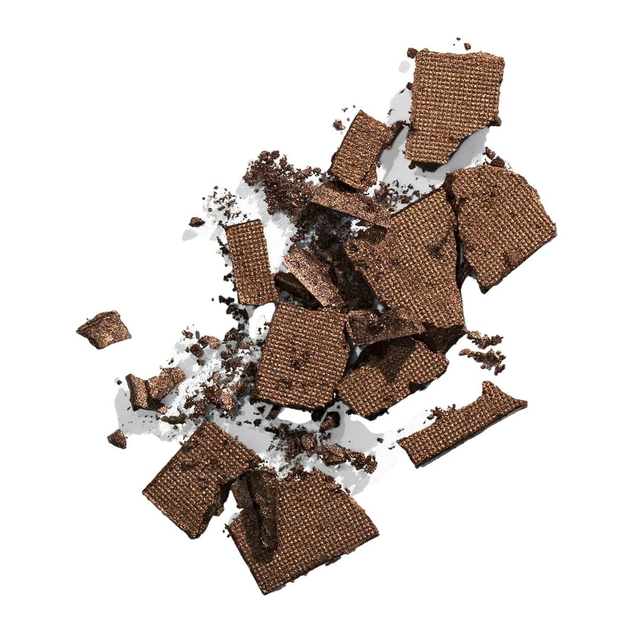 Bruchstücke von braunem Puder auf weißem Hintergrund. Die Textur ist sichtbar.