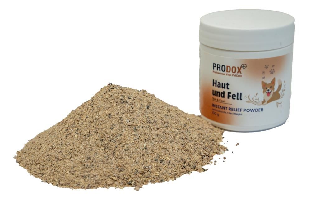 Weißer Behälter mit Deckel und Pulverhaufen. Aufschrift: PRODOX, Haut und Fell, INSTANT RELIEF POWDER. Pulver in Haufenform.