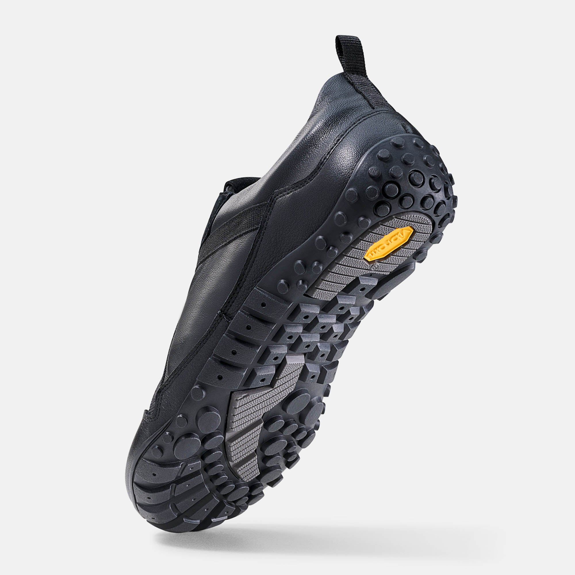 Schwarzer Herren-Schnürschuh. Unterseite mit Profilsohle. Gelbes Vibram-Logo. Breiter Schuh.