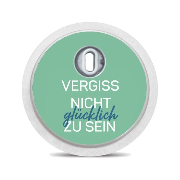 Runder Aufkleber, grün, Text: Vergiss nicht glücklich zu sein. Weißer Rand, Loch in der Mitte.