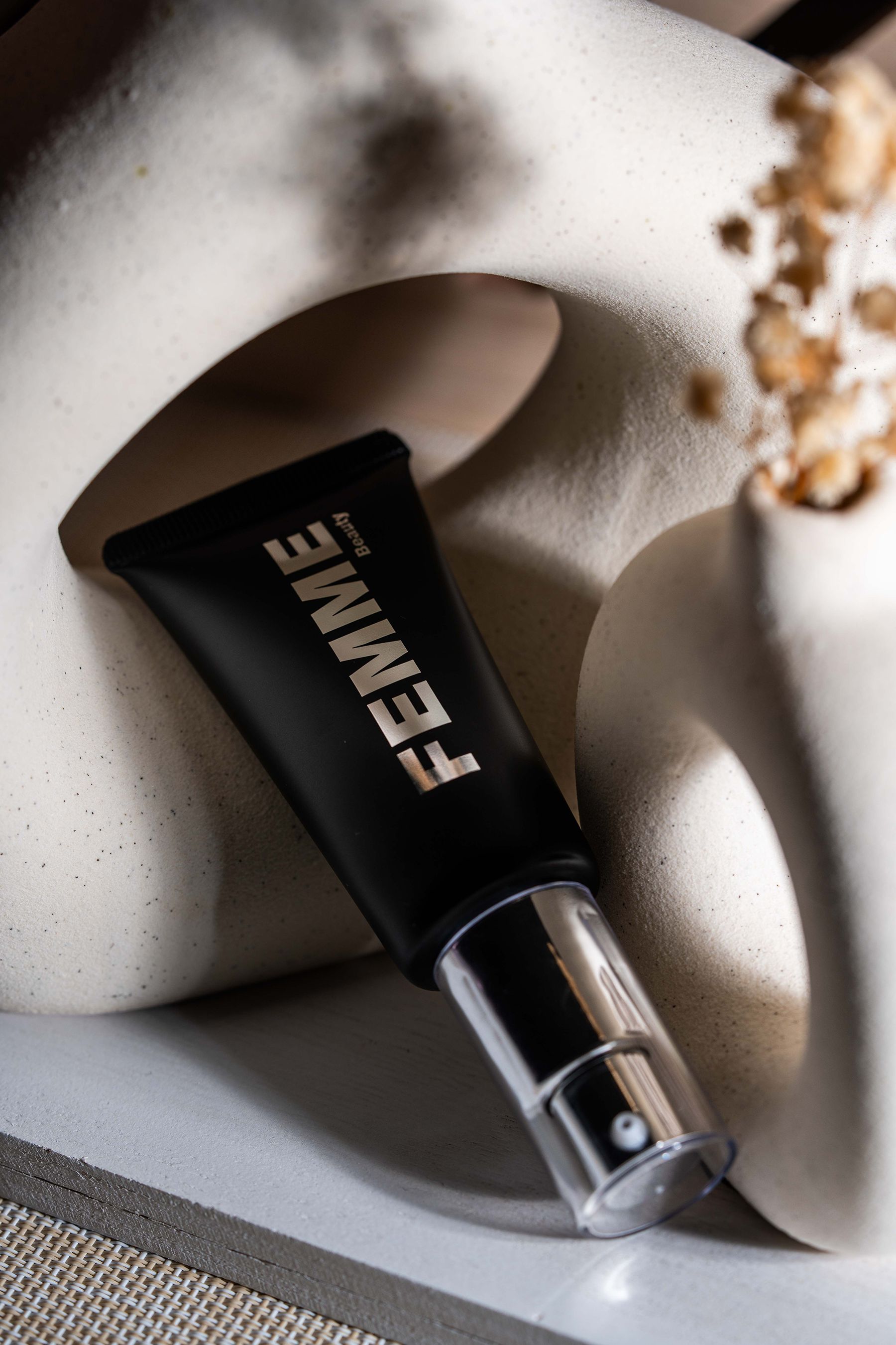 FEMME Intense Hide Concealer, schwarze Tube mit silbernem Pumpspender, schräg liegend.