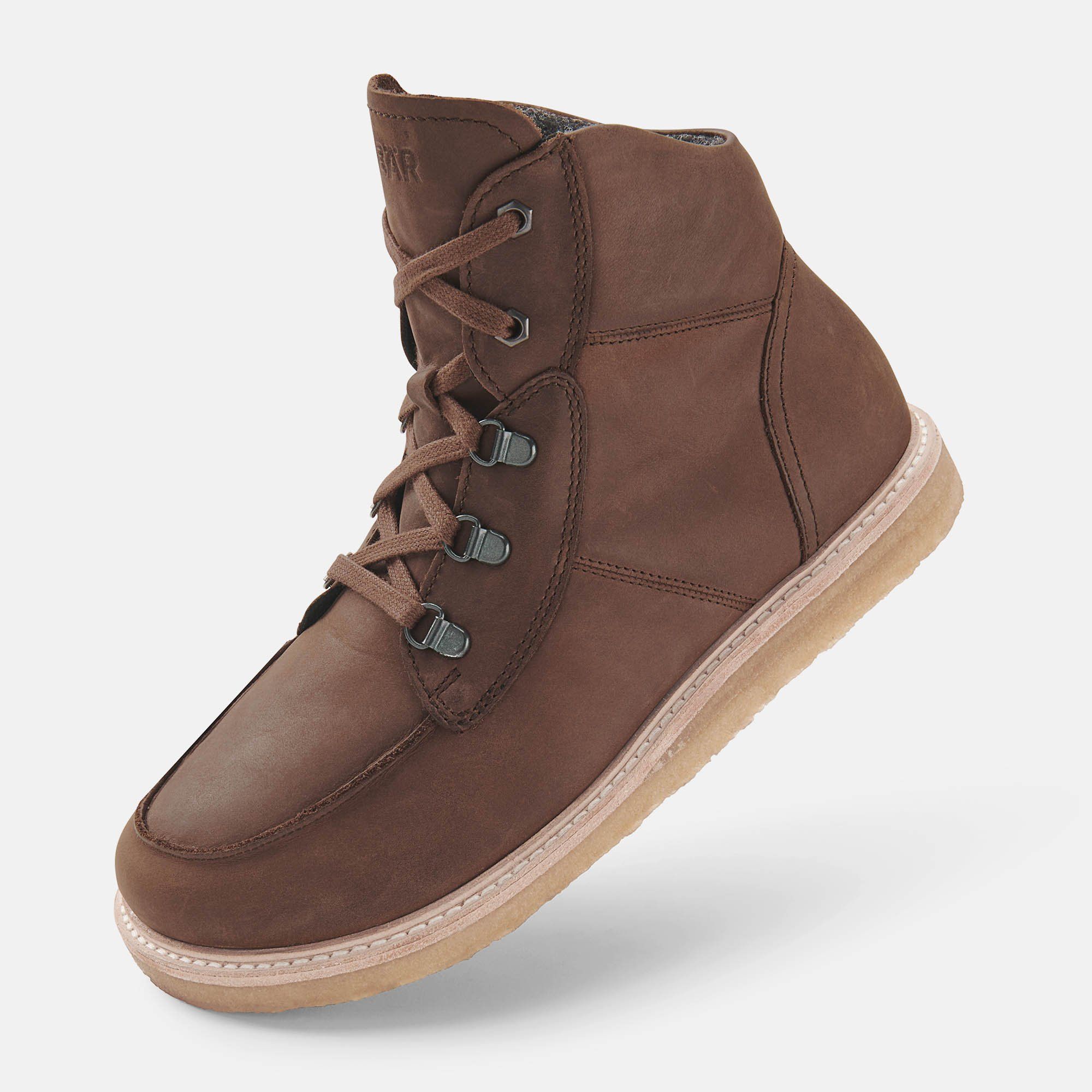 Braune Stiefelette mit Schnürung und hellbrauner Sohle. Metallösen für die Schnürsenkel. Schuh steht schräg.