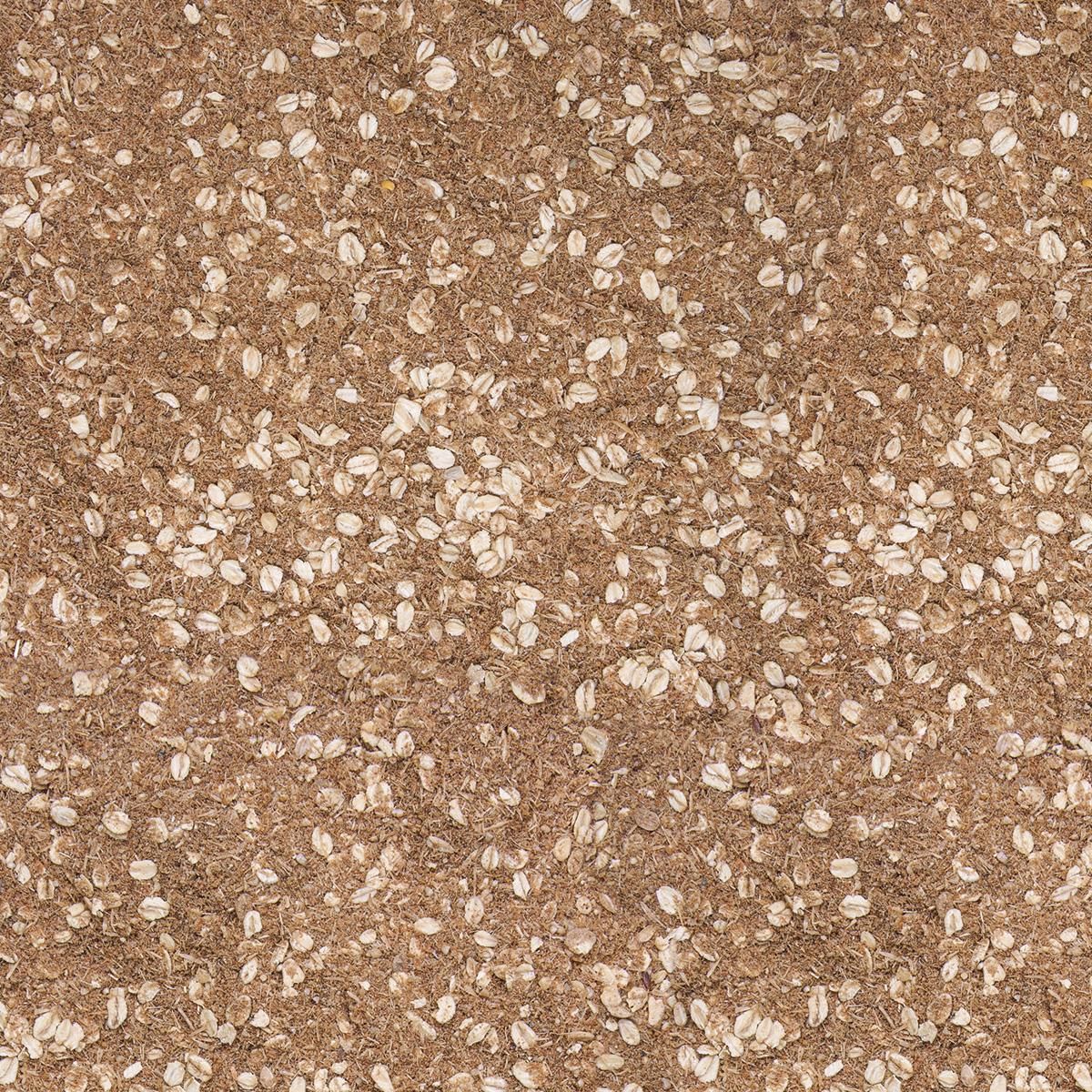 Nahaufnahme von braunem, körnigem Produkt mit weißen Flocken. Texturdetail, vermutlich Tierfutter.