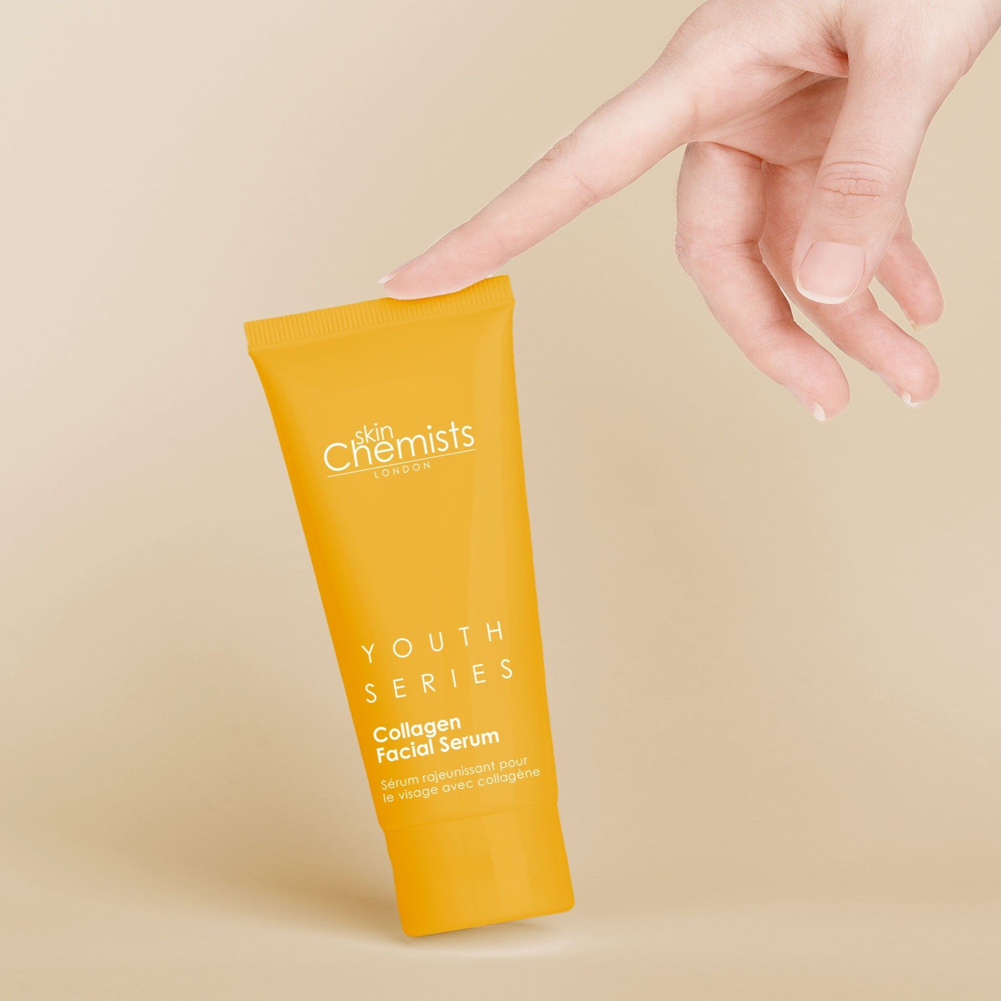 Gelbe Tube, gehalten von einer Hand. Produktname: Collagen Facial Serum. Marke: skinChemists London.