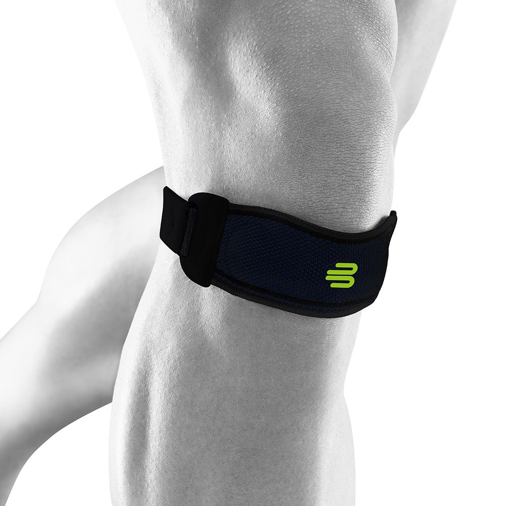 Kniestrap am Knie. Schwarz mit grünem Logo. Klettverschluss. Mesh-Material.