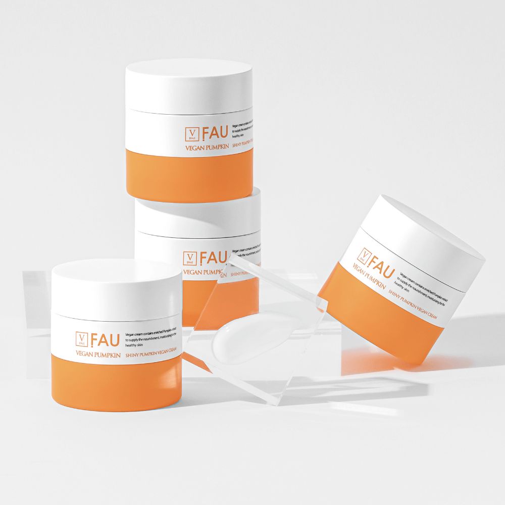 Mehrere Behälter mit weißem Deckel und orangefarbenem Boden. Aufschrift: FAU Vegan Pumpkin Shiny Pumpkin Vegan Cream. Mit Spatel.