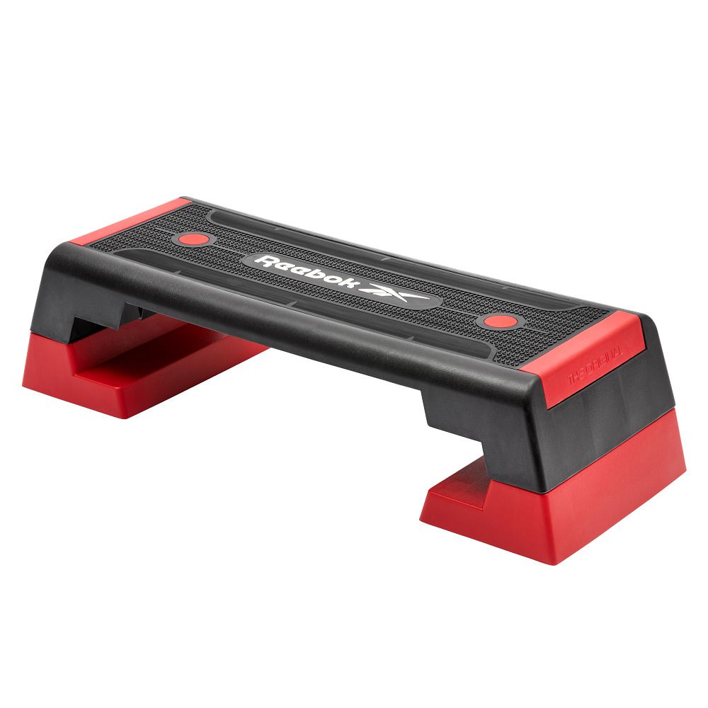 Ein schwarzer und roter Reebok Aerobic-Stepper. Schwarze Oberfläche mit Reebok-Logo und roten Füßen.