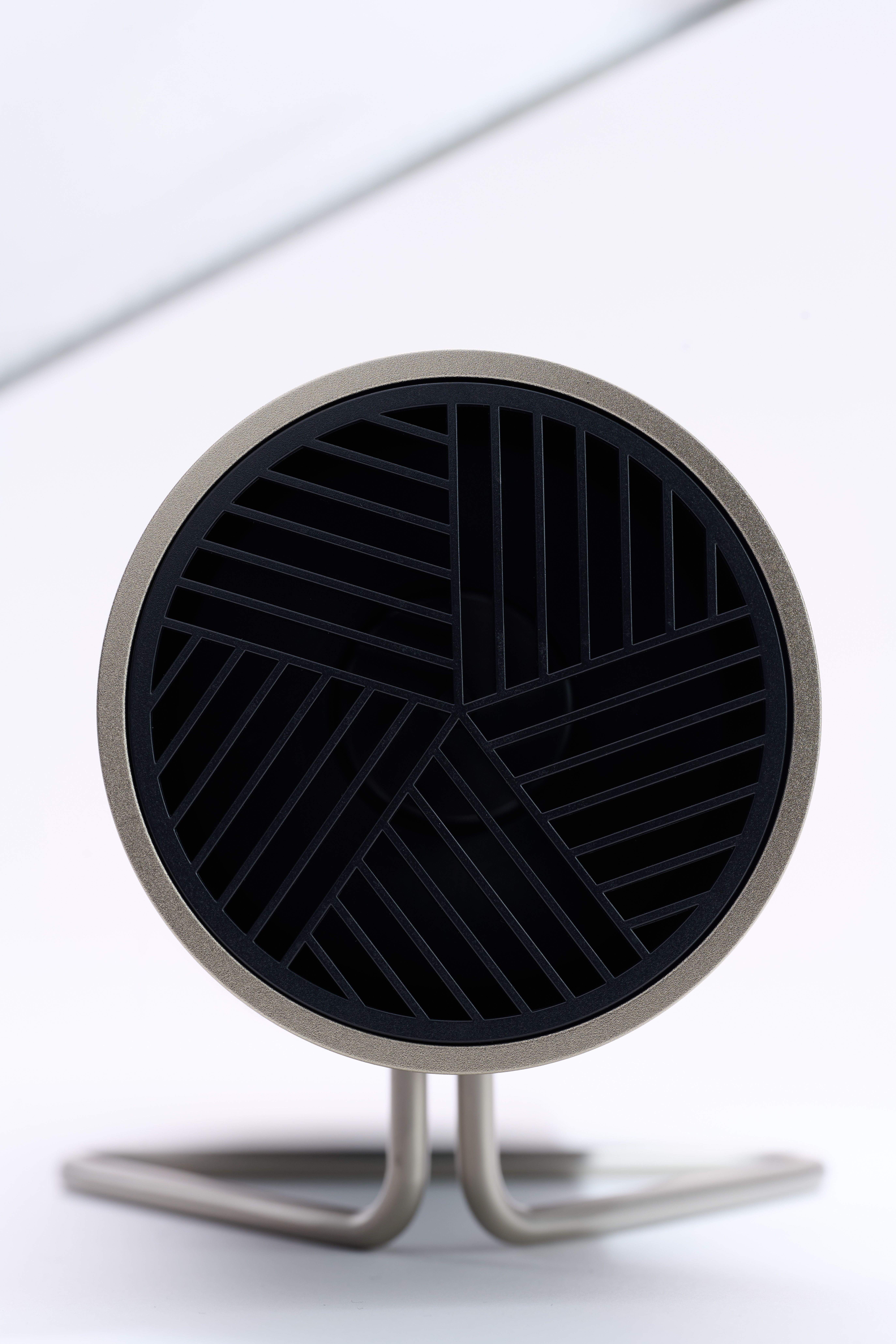 Draufsicht auf ein Gerät mit schwarzem, gemustertem Deckel. Auf einem Metallständer.