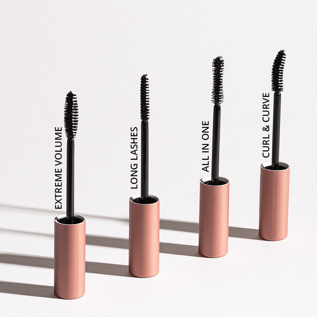 Vier Mascara-Tuben mit Bürsten. Aufschriften: Extreme Volume, Long Lashes, All in One, Curl & Curve. Rosafarbene Deckel.