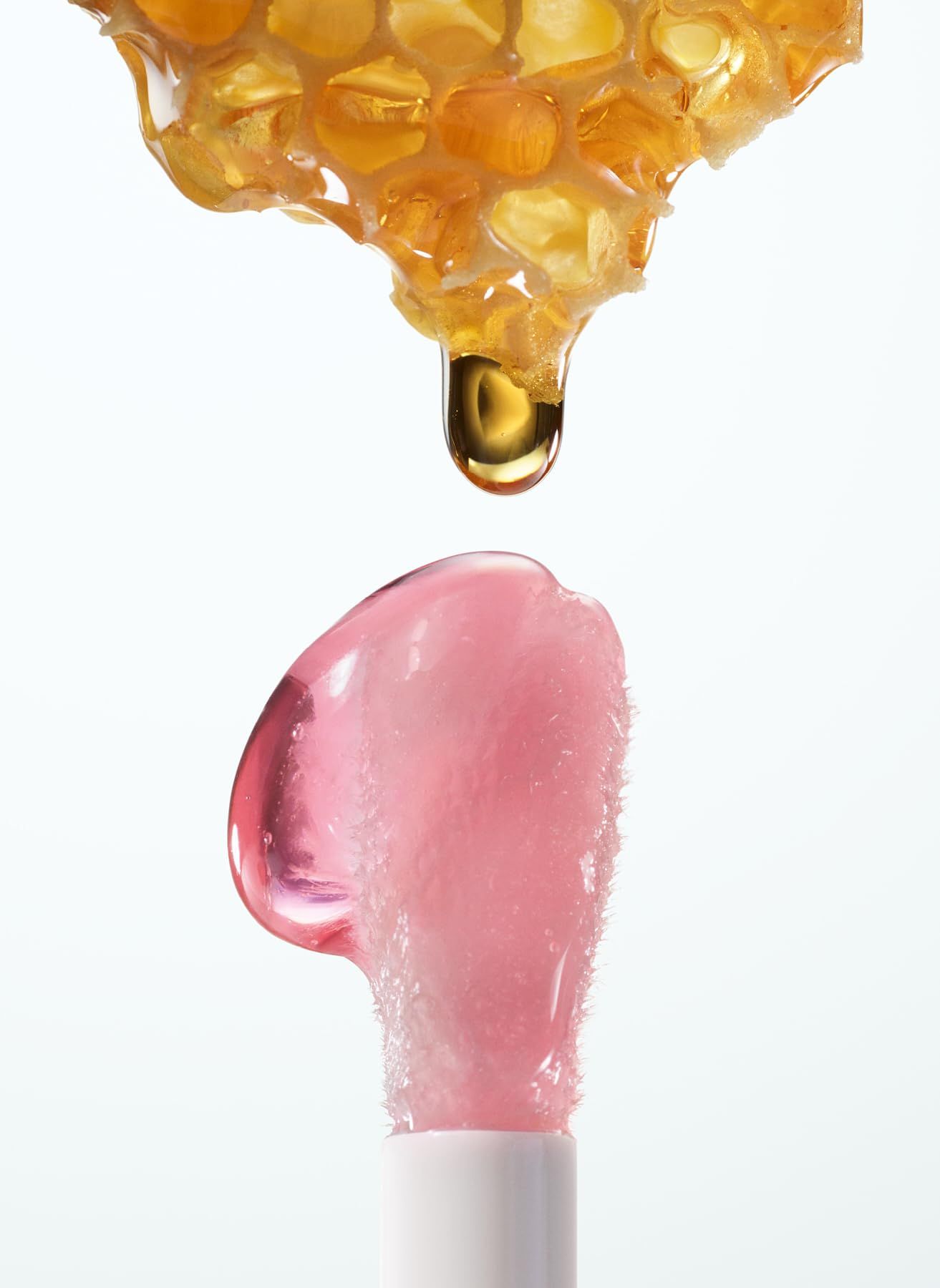 Lipgloss-Applikator mit Honigwabe und Tropfen. Rosa Gloss.