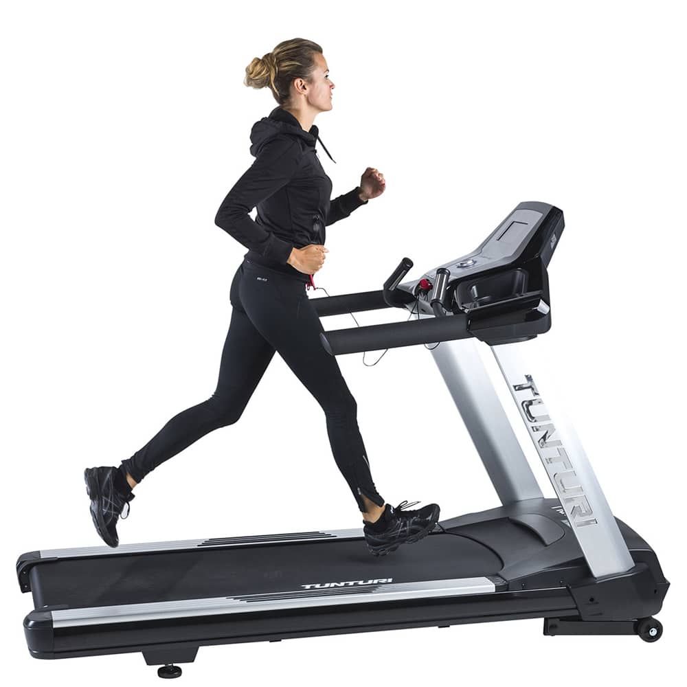 Person läuft auf einem Laufband. Das Laufband ist silber-schwarz. Tunturi-Logo sichtbar. Frau in Sportkleidung.