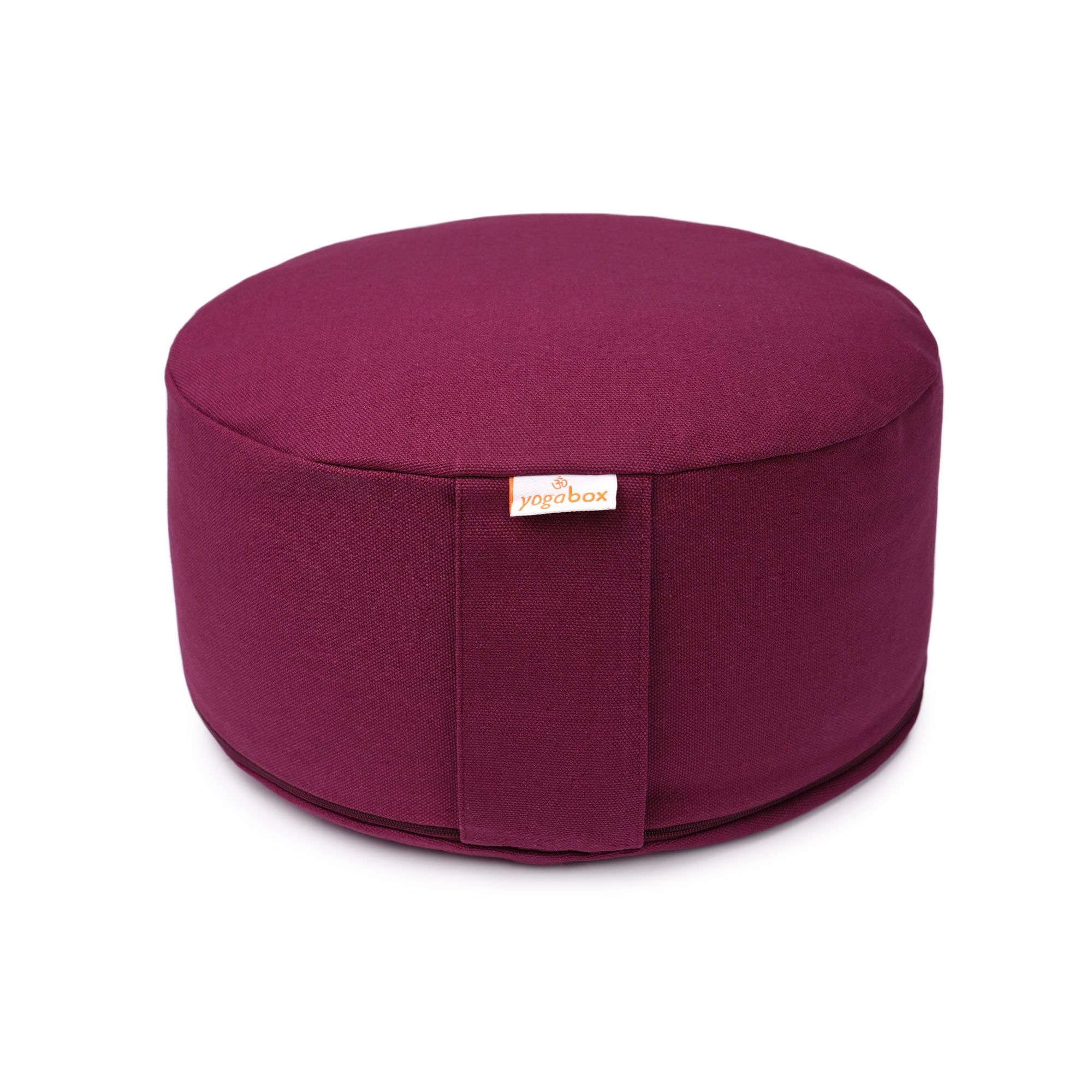 Rundes Meditationskissen in Aubergine mit seitlichem Griff und Markenlogo.