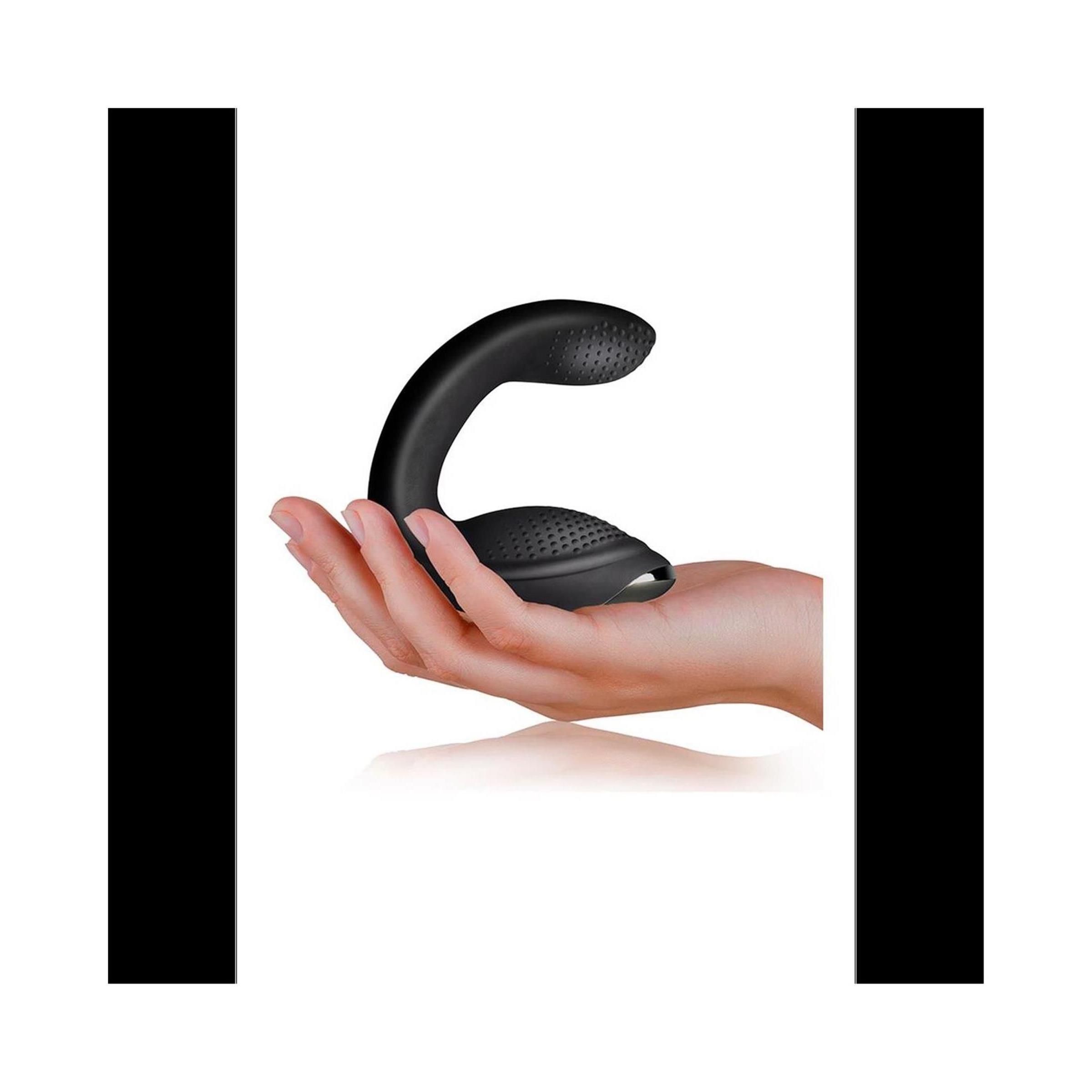 Schwarzes Wellness-Produkt in einer Hand gehalten. Produkt mit strukturierten Oberflächen. Helle Haut. Weißer Hintergrund.