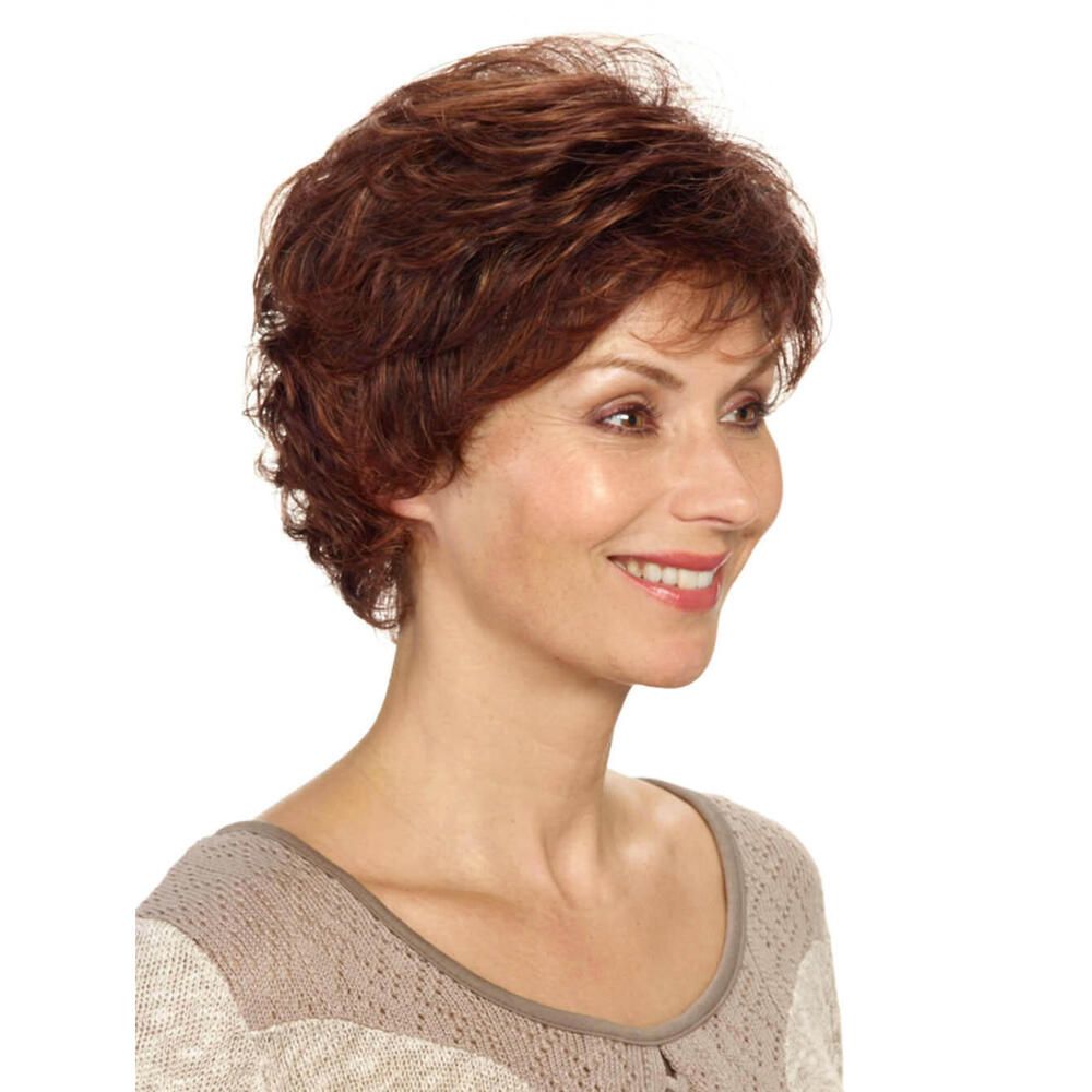 Kurzhaarperücke, rotbraun, gewellt. Frau mit Perücke, lächelnd. Beige Oberteil. Seitenansicht.