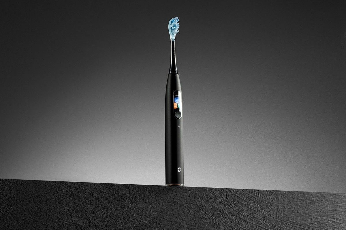 Schwarze elektrische Zahnbürste, blaue Borsten. Oclean X Ultra.