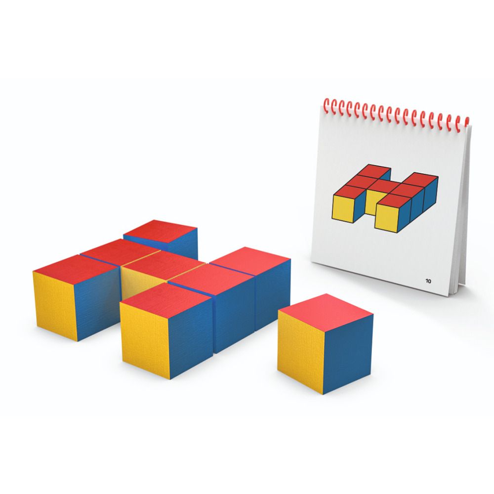 Mehrere bunte Würfel und ein Heft mit Vorlagen. Würfel in Gelb, Rot und Blau. Das Heft ist aufgeschlagen.