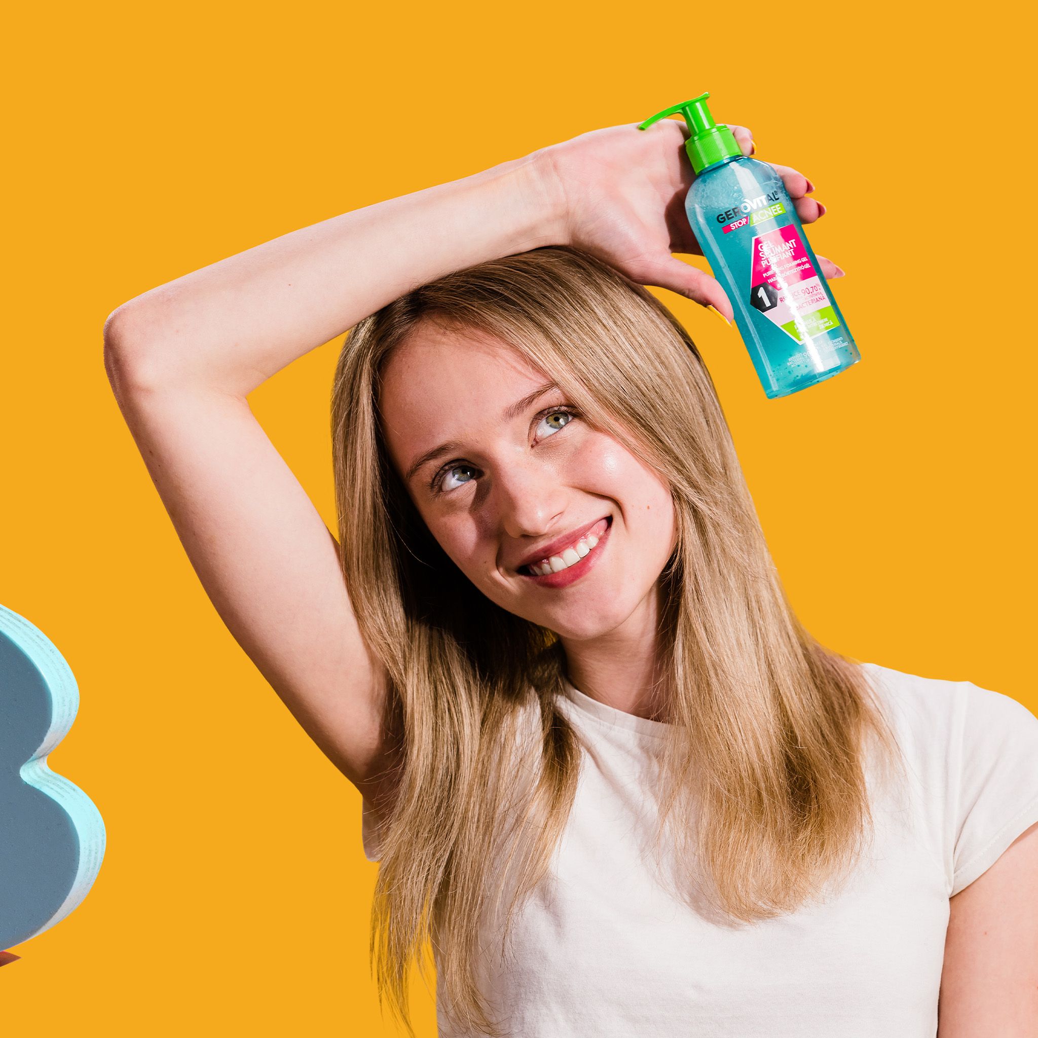 Eine Frau hält eine Flasche hoch. Gel wird auf die Hand aufgetragen. Gelb-oranger Hintergrund.