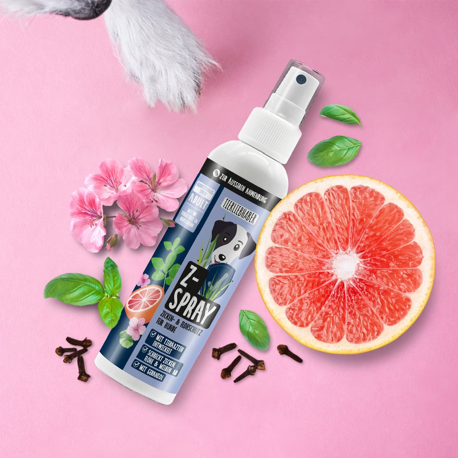 Weiße Sprühflasche mit blauem Etikett, Z-Spray-Logo, Hund, Grapefruit, Nelken, Blüten und Blättern. Pinker Hintergrund.