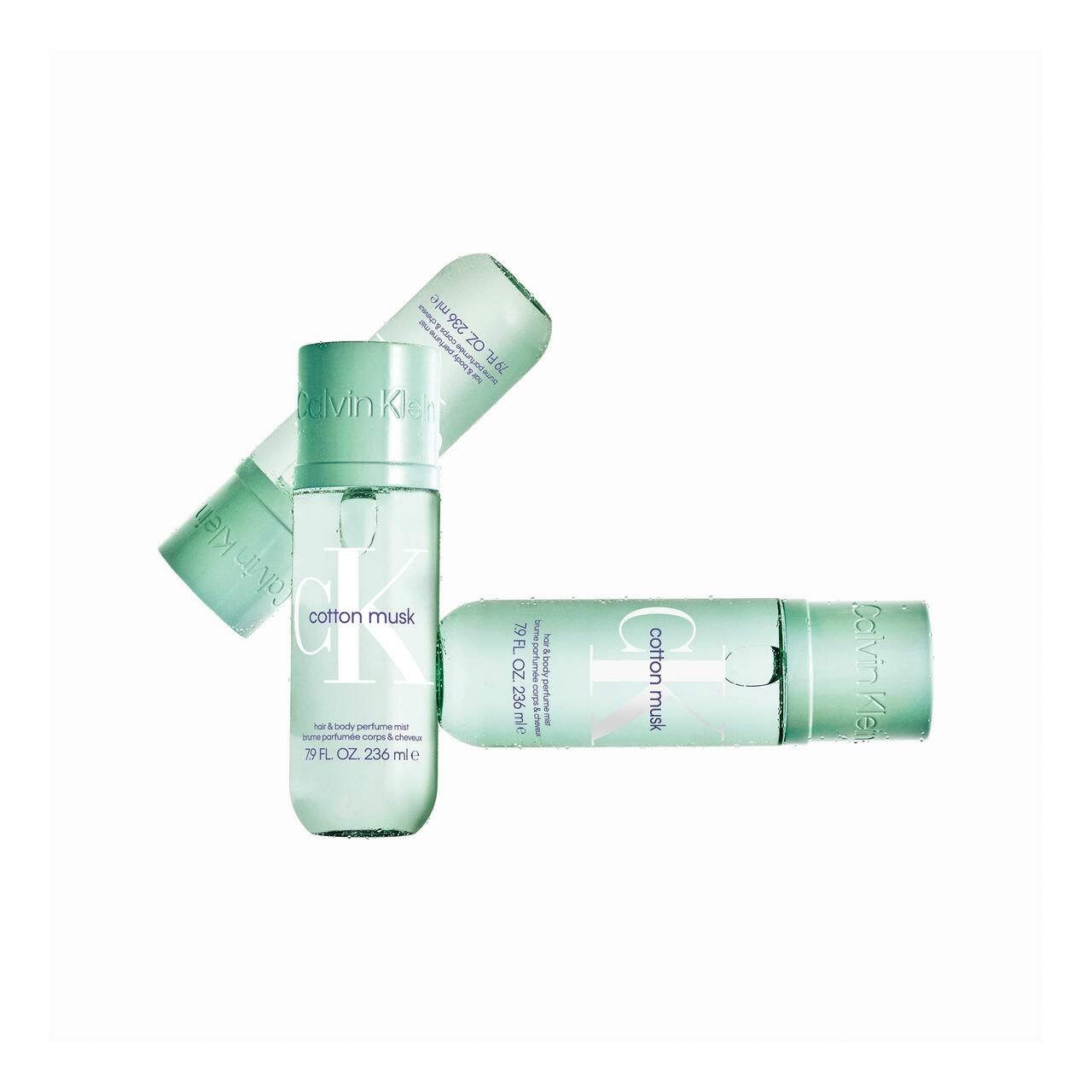 Drei grüne Flaschen mit Sprühkopf. Aufschrift Calvin Klein, cotton musk, hair & body perfume mist. 79 FL. OZ. 236 ml e.