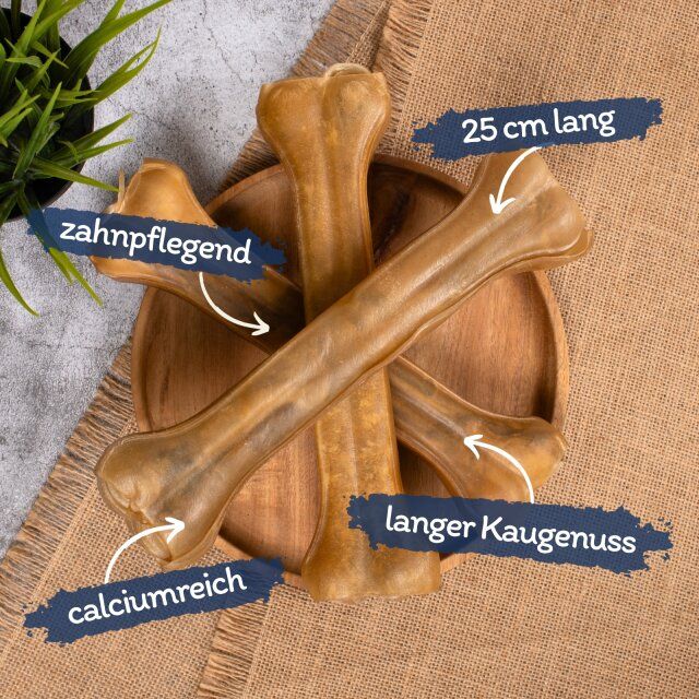 Kauknochen auf Holzplatte. Beschriftungen: 25 cm lang, calciumreich, langer Kaugenuss, zahnpflegend.