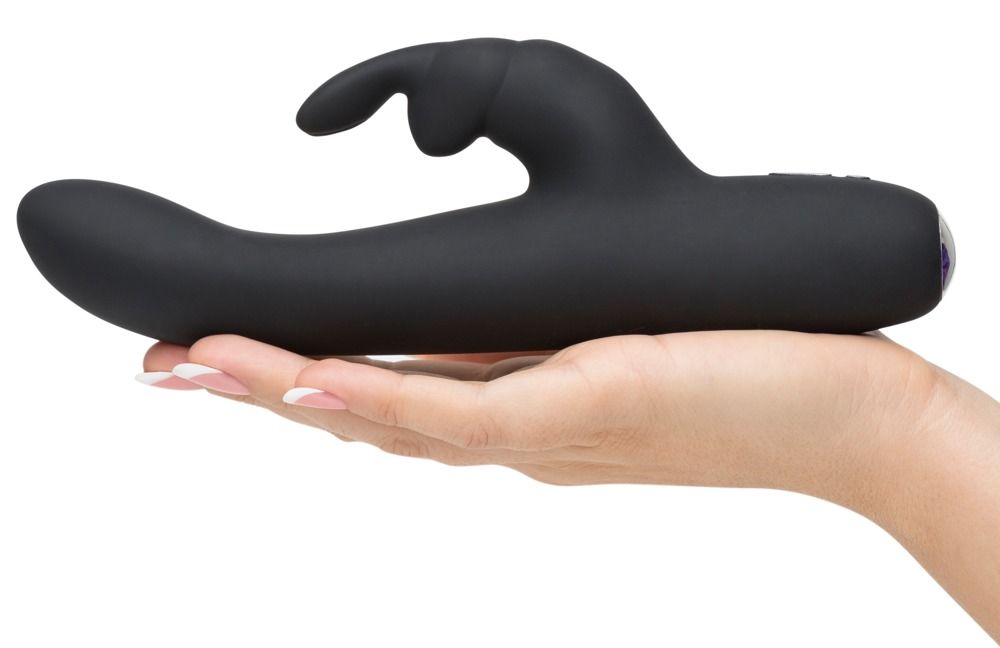 Schwarzer Vibrator in Hand gehalten. Silikon-Oberfläche, ergonomische Form mit Kaninchenohren. Lila Akzent am Ende.