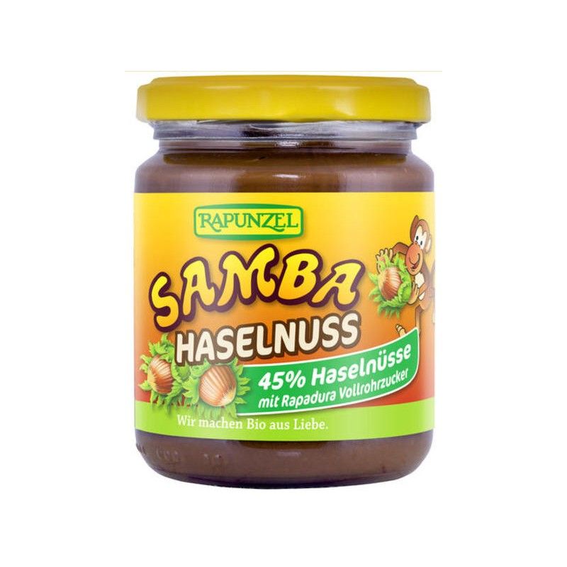 Glas mit Aufschrift "RAPUNZEL SAMBA HASELNUSS". Etikett mit Haselnüssen und Affe. Gelber Deckel. Aufschrift: 45% Haselnüsse.