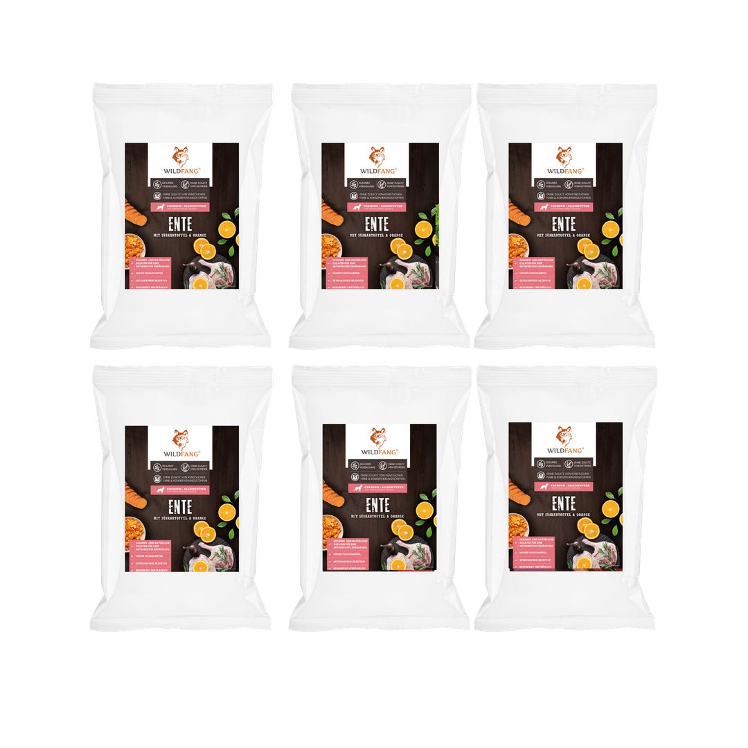 Sechs weiße Beutel Trockenfutter mit Enten-Abbildung, Karotten und Orangen. Produktinformationen und Logo.