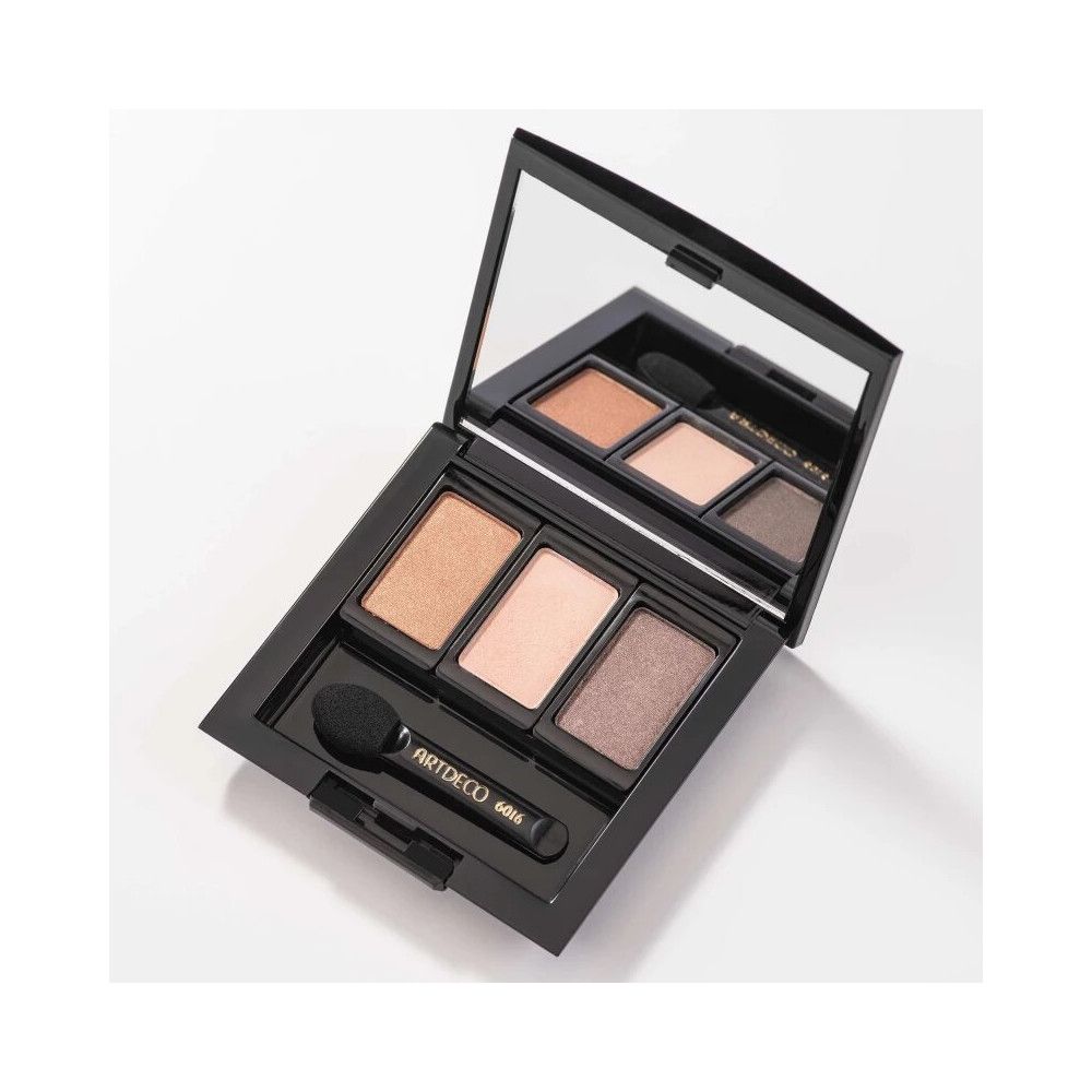 Schwarze Kosmetikpalette mit Spiegel und drei Lidschattenfarben. Ein Applikator liegt daneben. Auf dem Griff steht ARTDECO 6016.