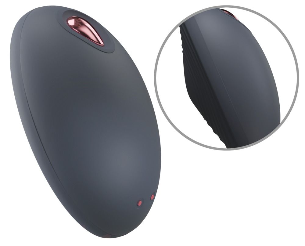 Dunkelgrauer, ovaler Vibrator mit roségoldfarbenem Akzent. Zwei kleine, rote Punkte. Detailansicht der geriffelten Seite.