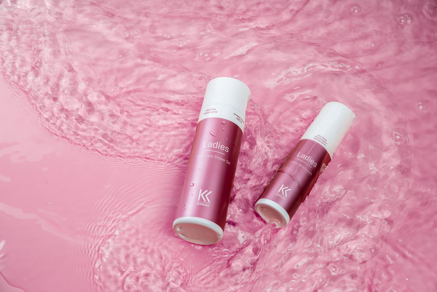 Zwei Spender im rosa Wasser. Aufschrift "Ladies Intim-Care Cream" und Logo. Produkt für Intimpflege.