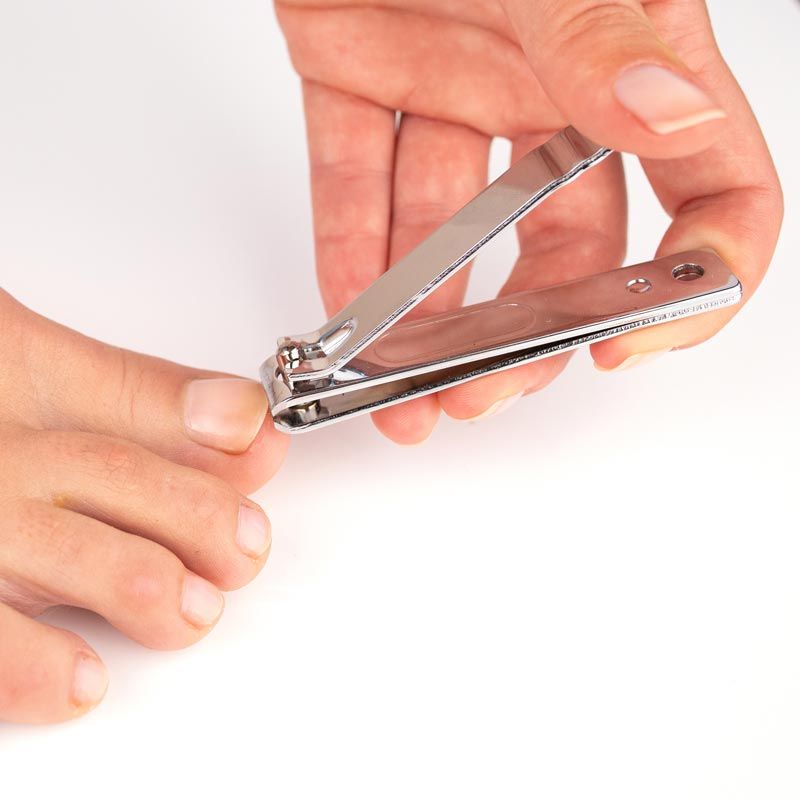 Person benutzt einen Nagelknipser für Zehennägel.