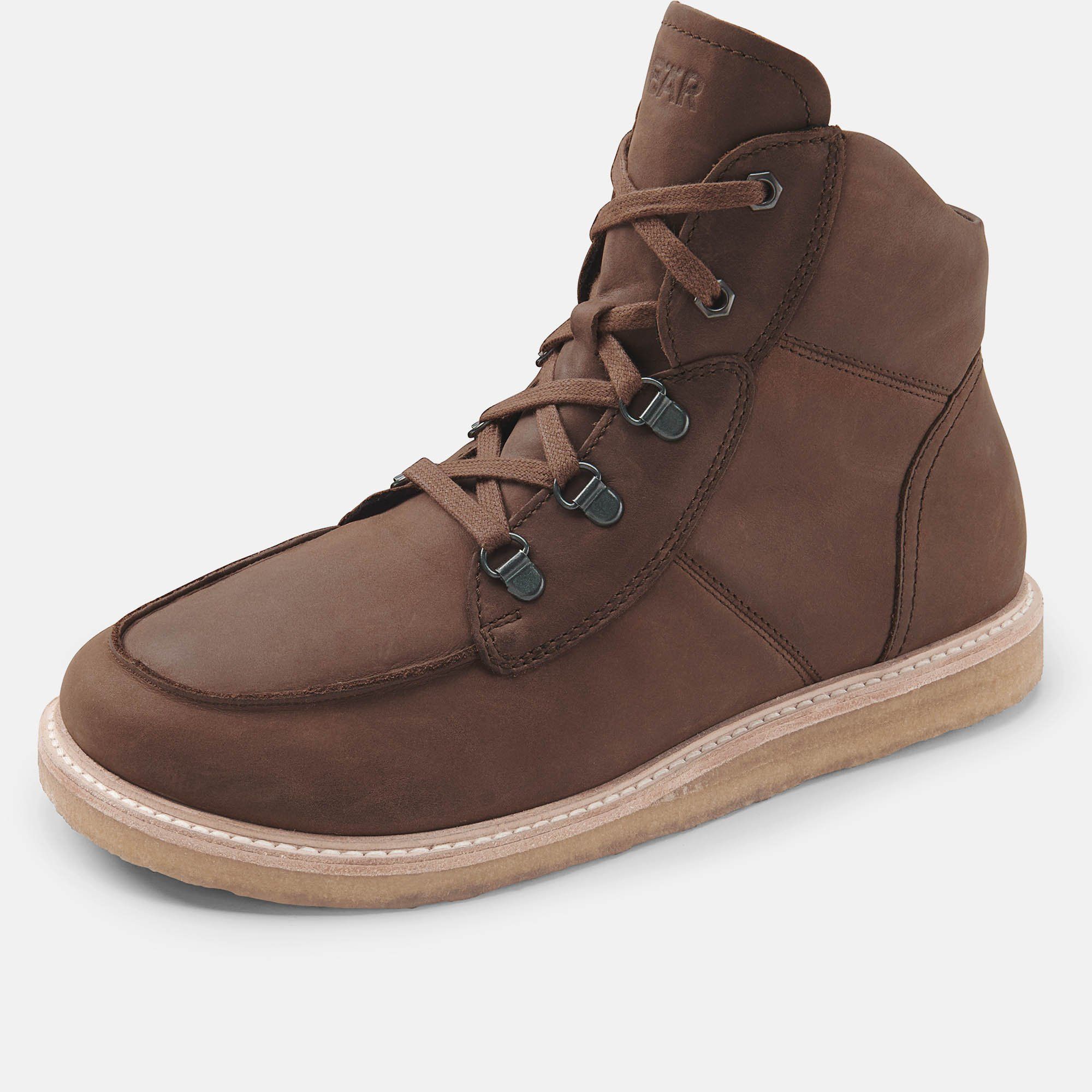 Braune Stiefelette mit Schnürung und hellbrauner Sohle. Metallösen für die Schnürsenkel. Schuh steht gerade.
