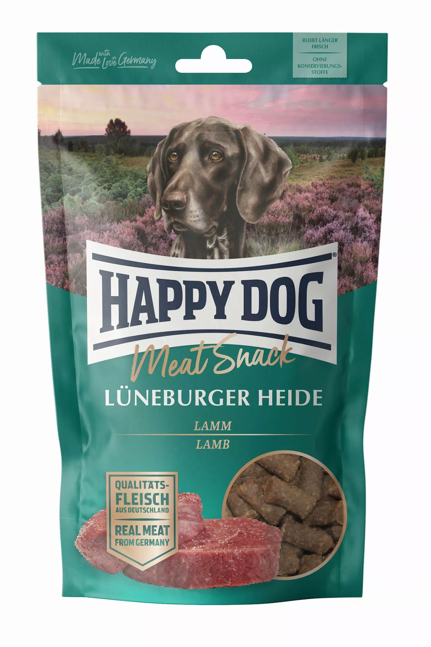 Verpackung von Happy Dog Meat Snack Lüneburger Heide. Grün, mit Hundefoto und Produktabbildungen. Text: Lamm, Qualitätsfleisch aus Deutschland.