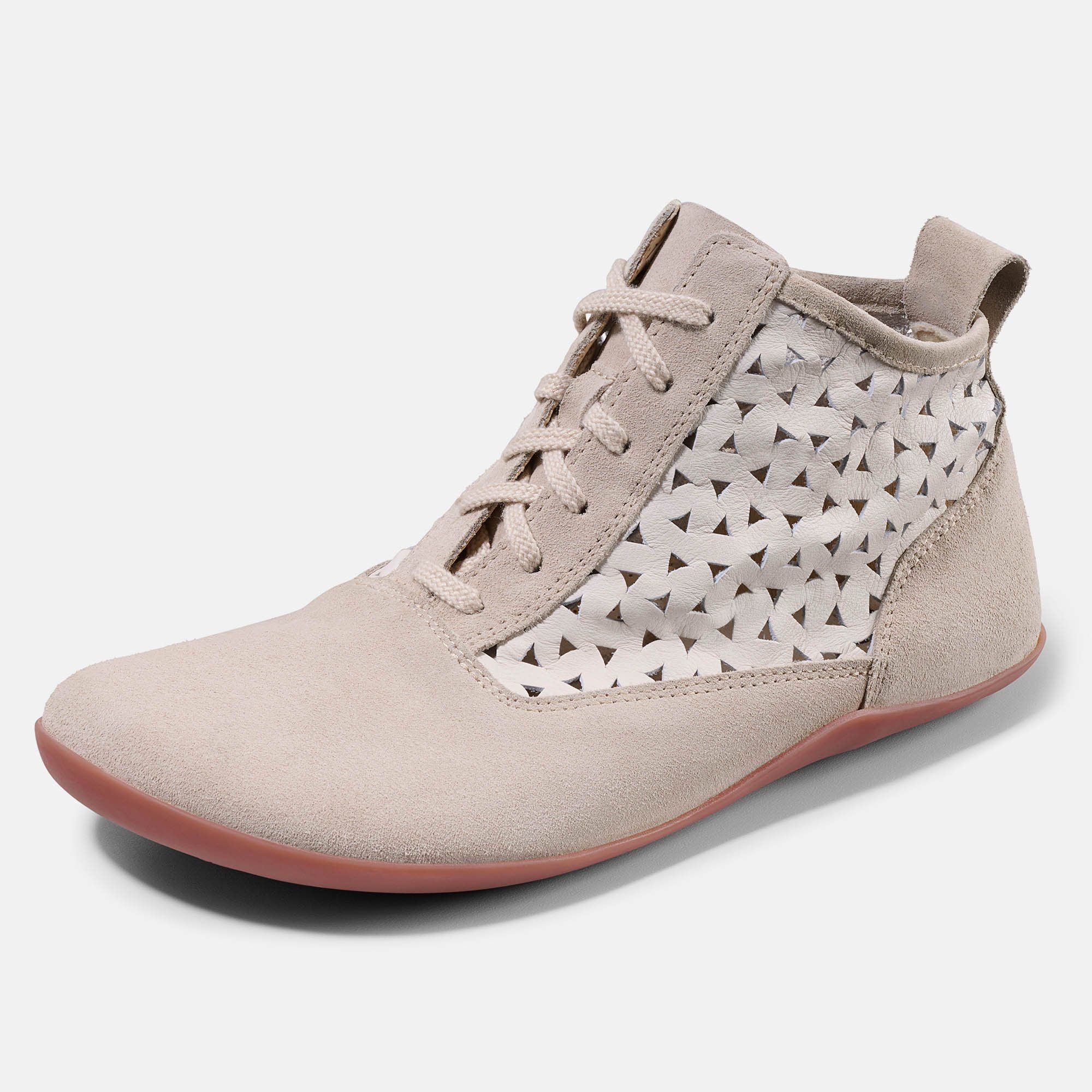 Beige Stiefelette mit Schnürung und Lochmuster. Rote Sohle. Wildleder-Details. Nahaufnahme.