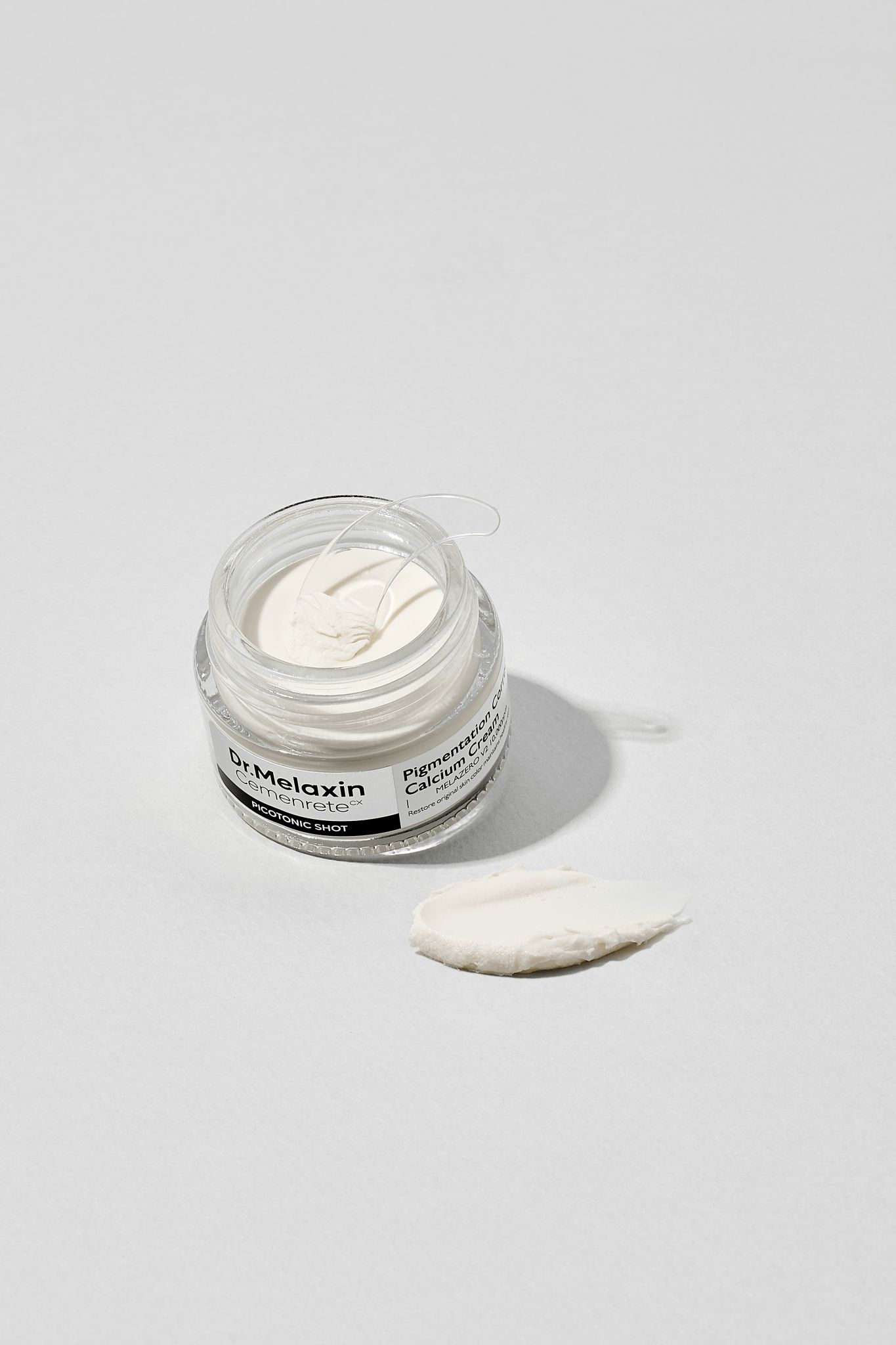 Dr.Melaxin Pigmentation Calcium Cream in einem Glasbehälter mit einer Probe daneben.