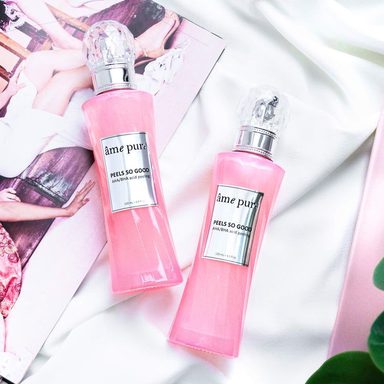 Twee roze flessen met zilveren etiketten. De flessen hebben een transparante deksel. Het etiket zegt 'âme pure'.