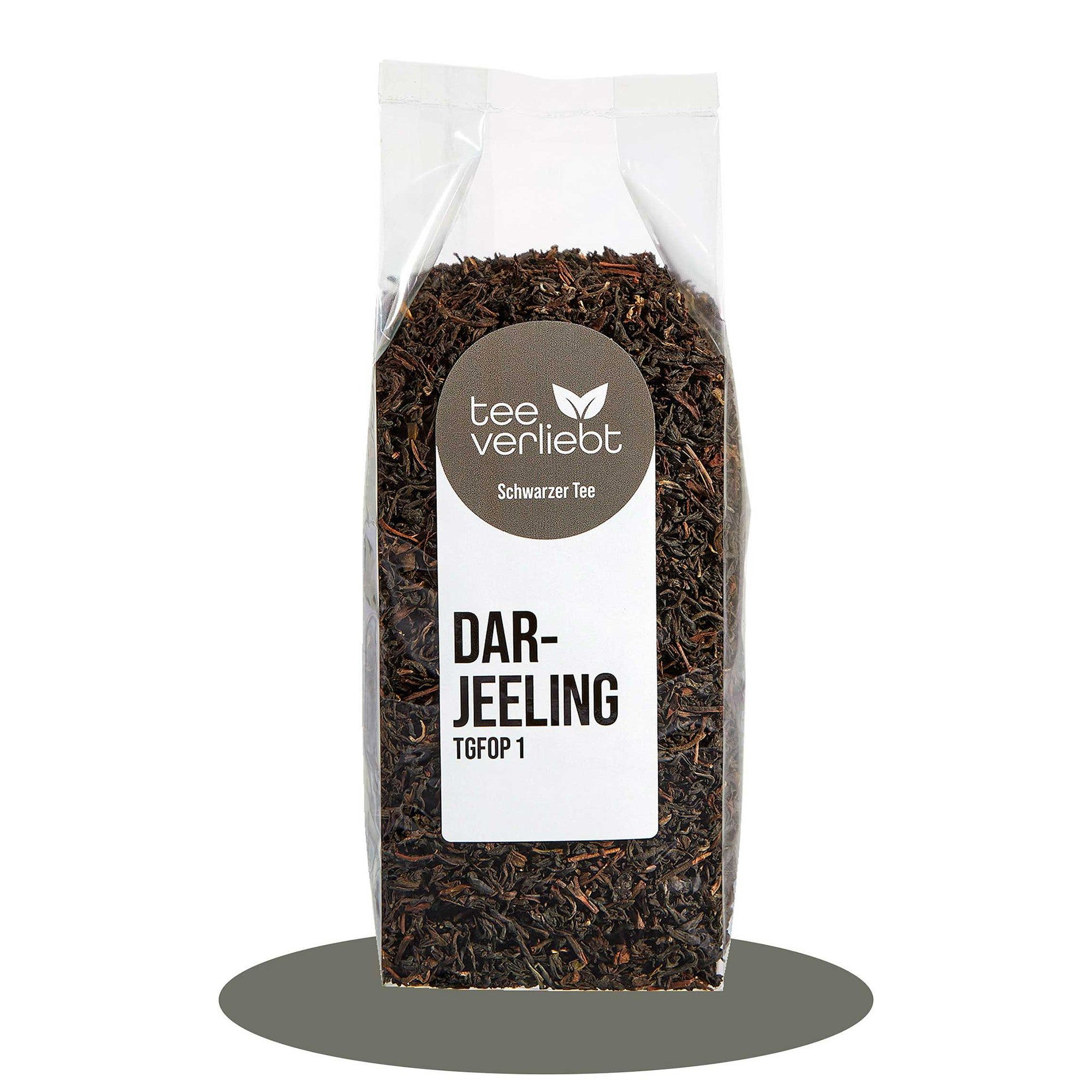 Transparente Verpackung mit losem Schwarztee. Aufkleber mit "tee.verliebt", "Darjeeling" und "Schwarzer Tee".