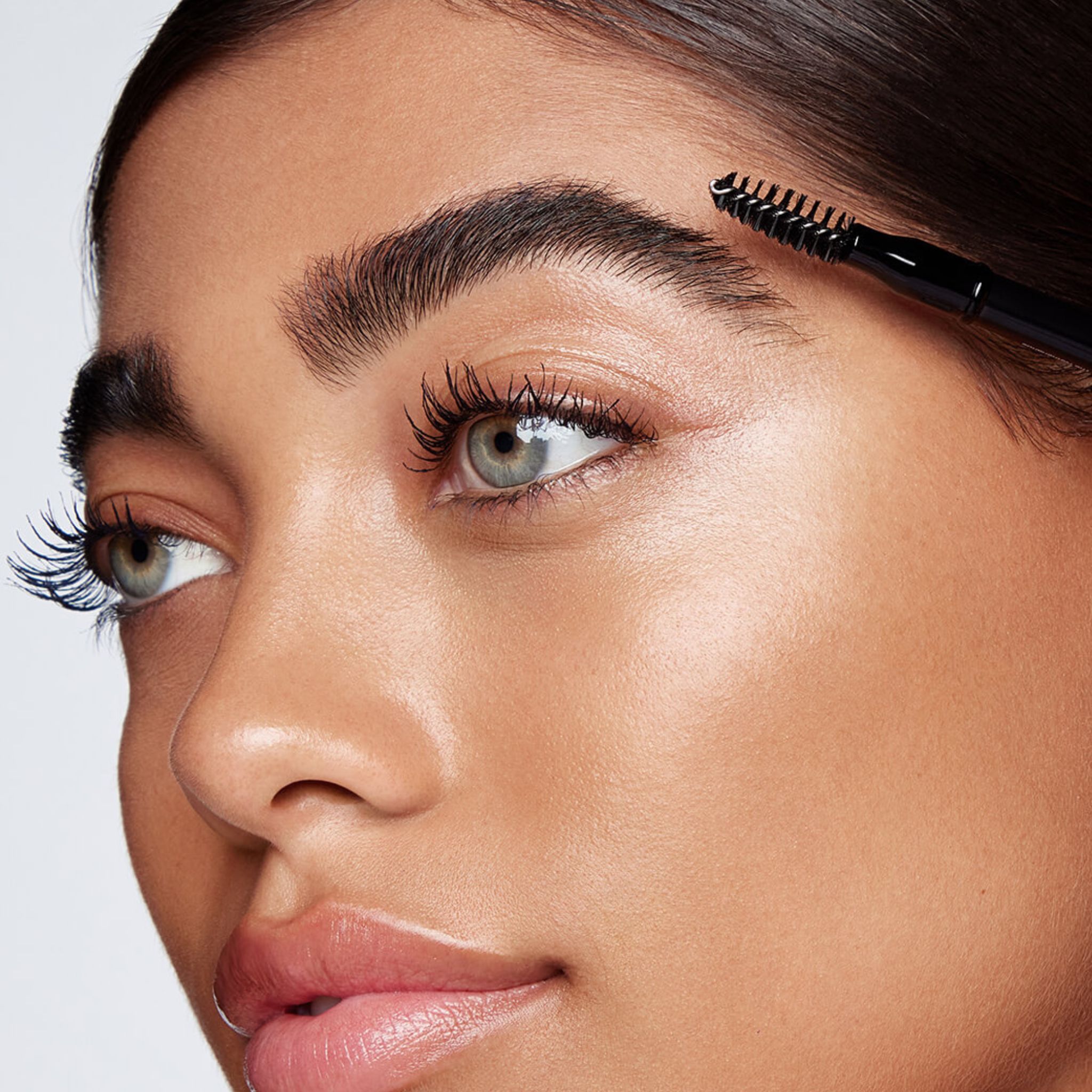 Nahaufnahme einer Frau, die ihre Augenbrauen mit dem RevitaLash Hi-Def Brow Pencil in Cool Brown formt.