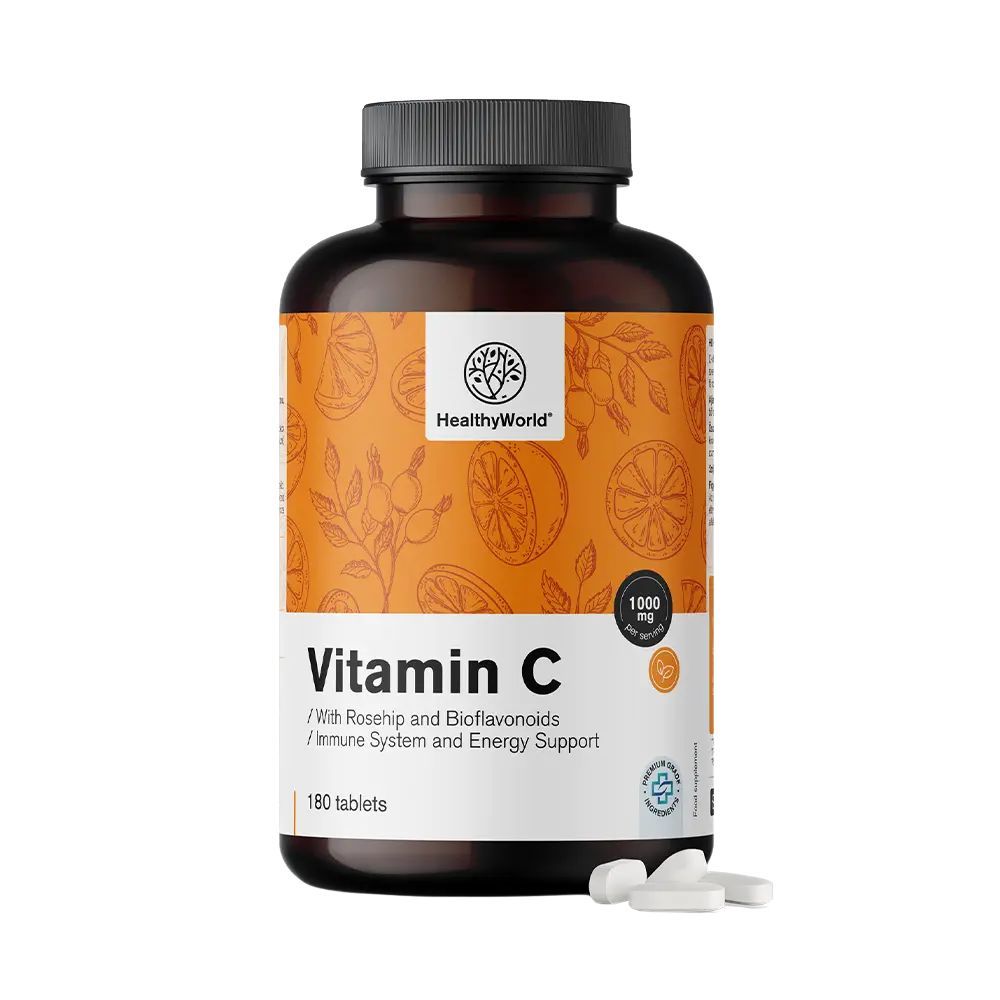 Braune Flasche mit Vitamin C-Tabletten. Aufschrift: HealthyWorld, Vitamin C 1000 mg, 180 Tabletten. Einige Tabletten liegen daneben.