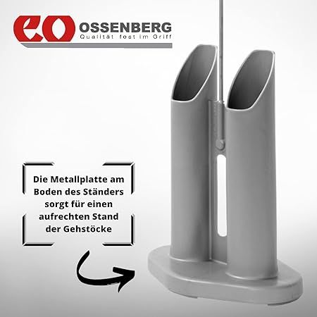 Grauer Stockständer mit zwei Halterungen. Text: 'Die Metallplatte am Boden des Ständers sorgt für einen aufrechten Stand der Gehstöcke.'