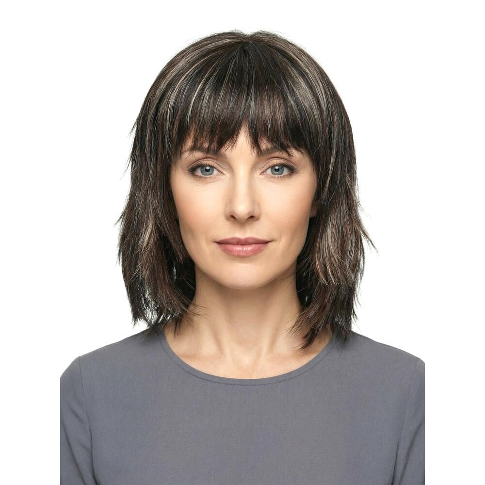Frau mit Perücke. Dunkelbraunes Haar mit helleren Strähnen, Pony. Frontansicht.
