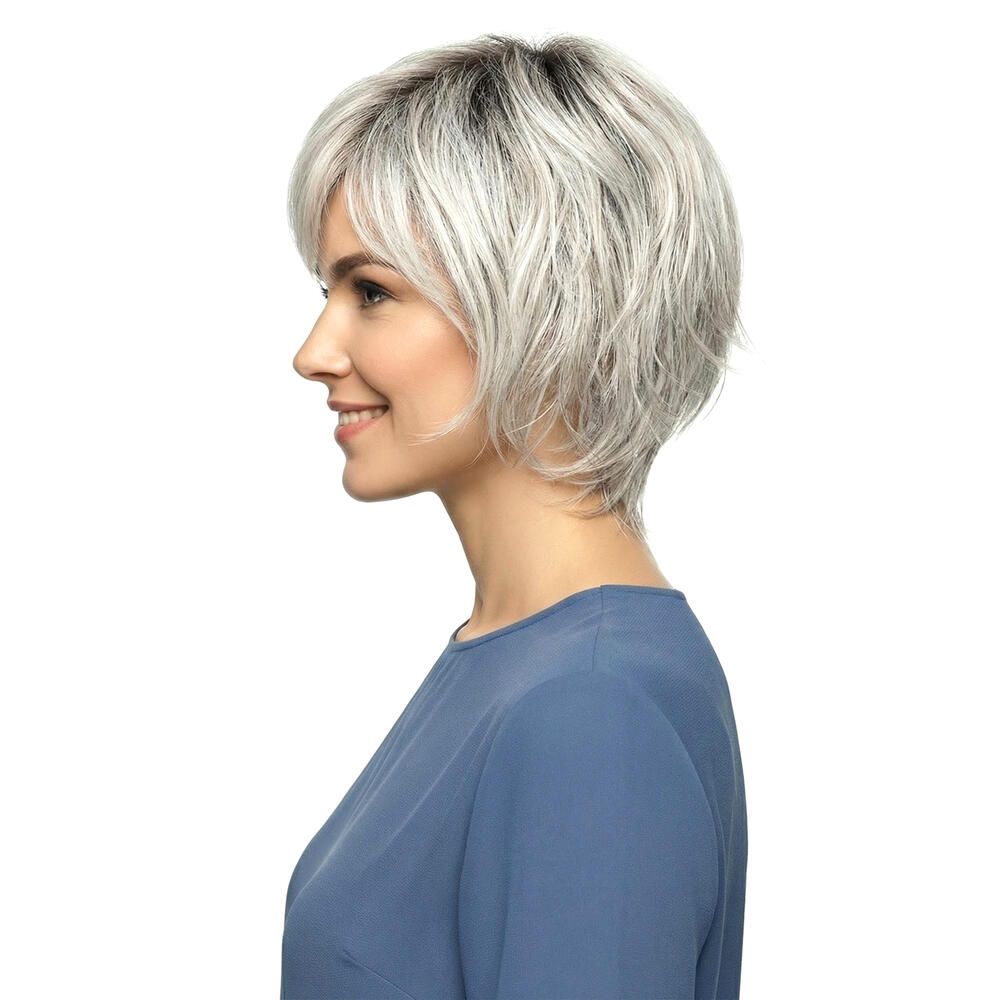 Grau-melierte Kurzhaarperücke mit Pony. Seitenansicht. Die Perücke wird von einer Frau mit blauem Oberteil getragen.