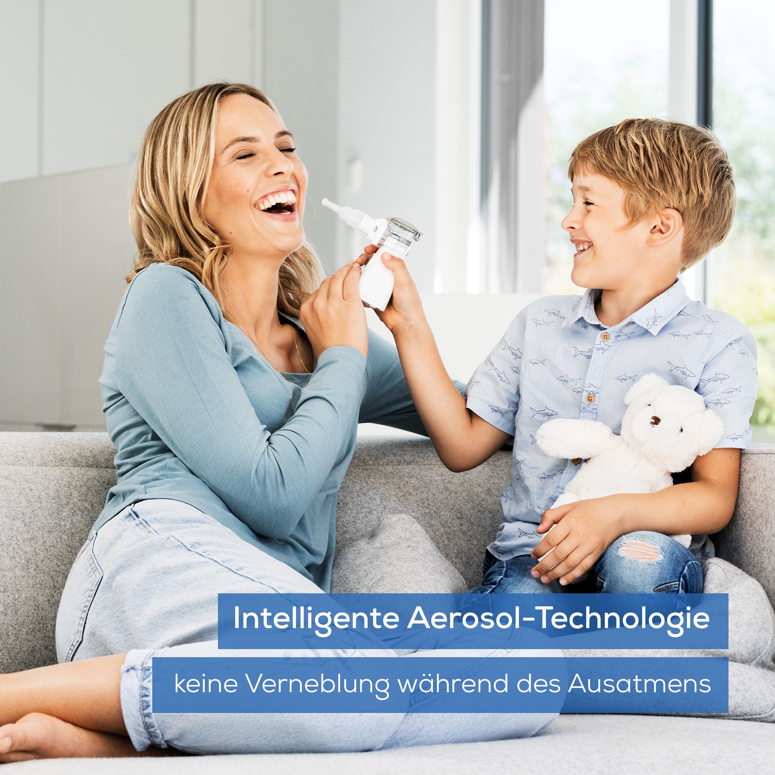 Mutter und Kind mit Beurer IH 57 Inhalator. Frau und Kind auf Sofa, Inhalator in der Hand.