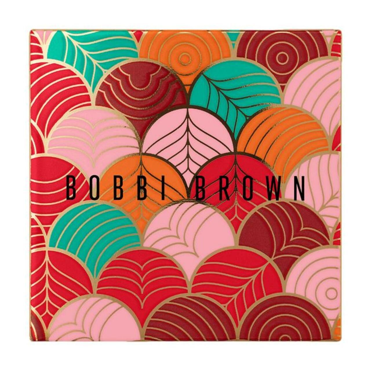 Quadratische Verpackung mit farbenfrohem, geometrischem Muster. Bobbi Brown-Logo in der Mitte. Goldene Akzente.