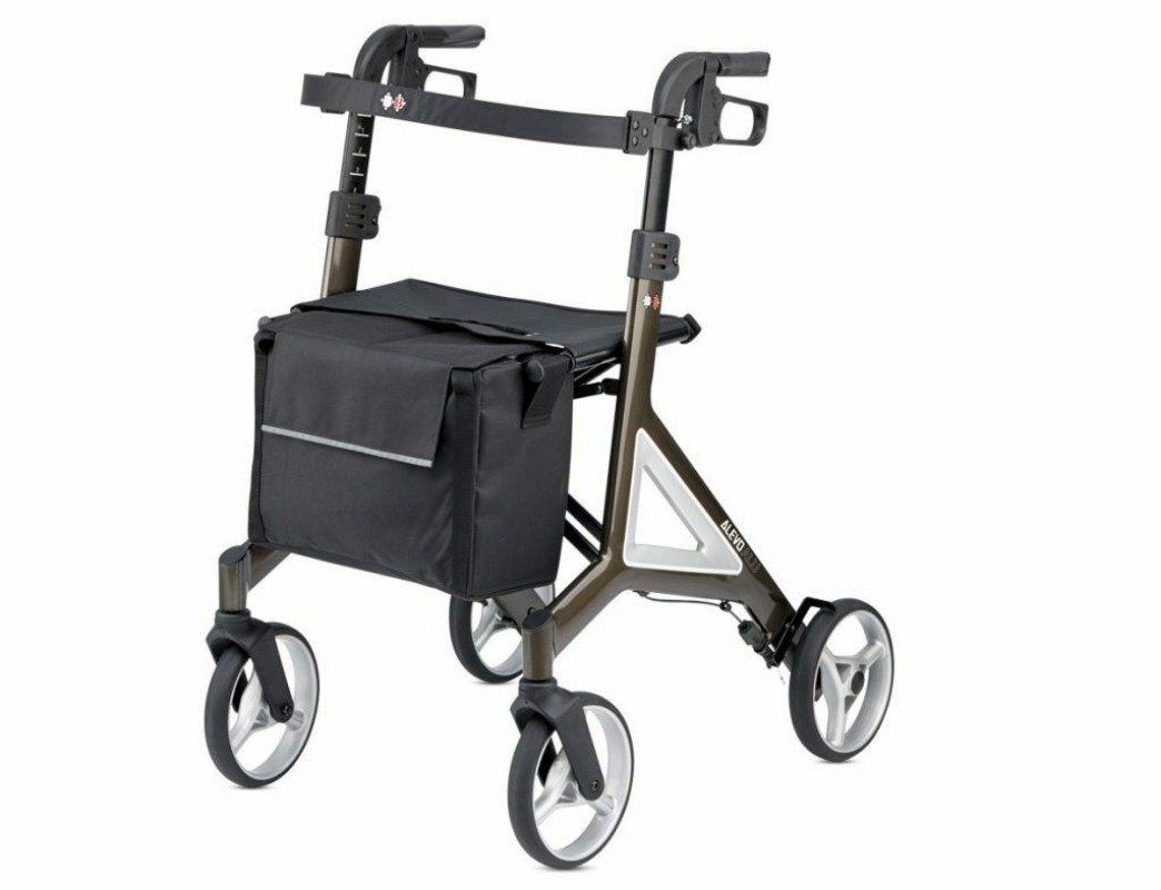 Rollator mit braunem Gestell, schwarzem Sitz und Tasche. Vier Räder, Griffe und Rückenlehne. Silberne Akzente.