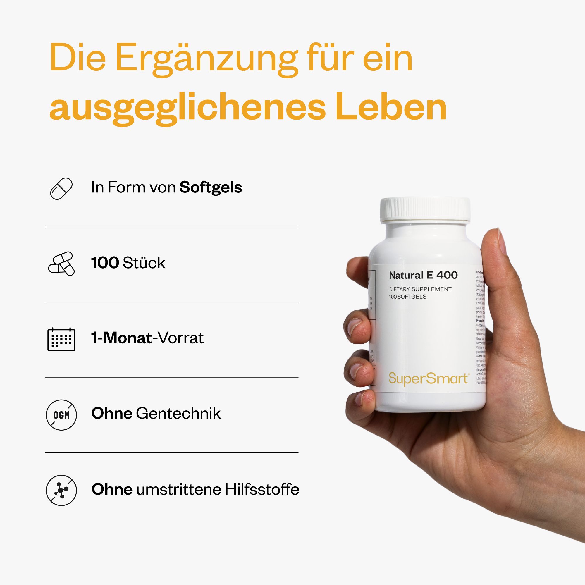 Hand hält eine weiße Flasche Natural E 400, 100 Softgels. Marke SuperSmart. Text: 1-Monats-Vorrat, ohne Gentechnik, ohne Hilfsstoffe.